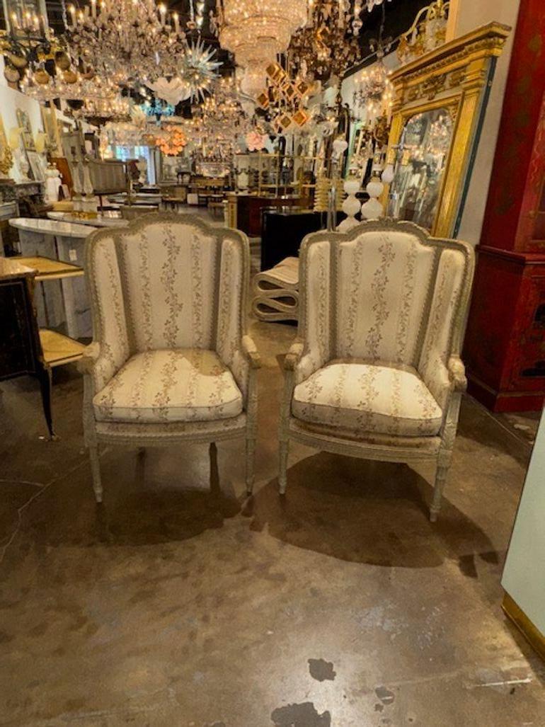 Si tratta di una coppia di bergère francesi Luigi XVI del XIX secolo che presentano intricati intagli e una finitura dipinta. Le sedie presentano uno stile classico Luigi XVI con un tocco di fascino antico, che le rende un pezzo d'arredamento di