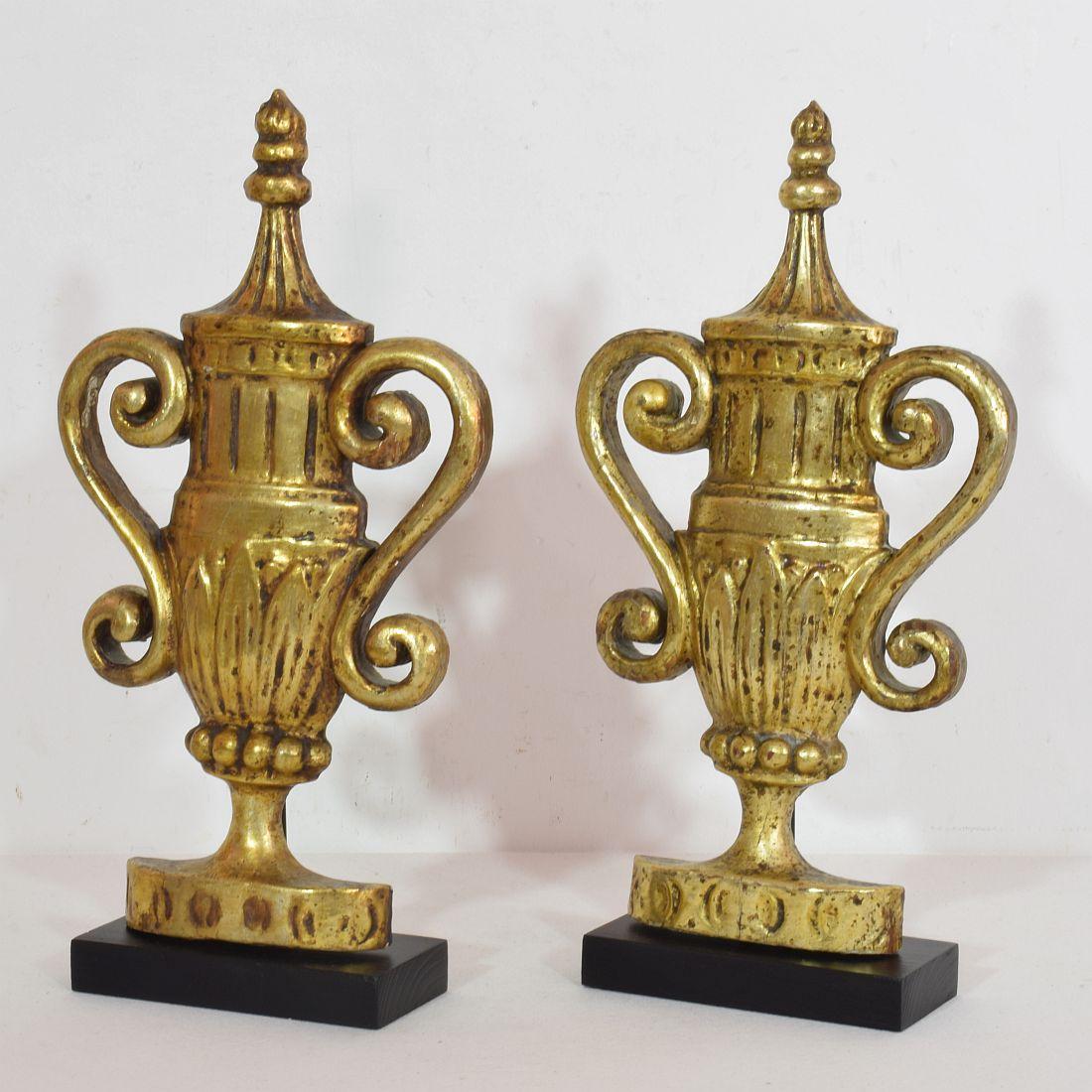 Nice couple of two giltwood ornaments in neoclassical style,
France, circa 1850. Weathered. Measurement here below includes the wooden base.