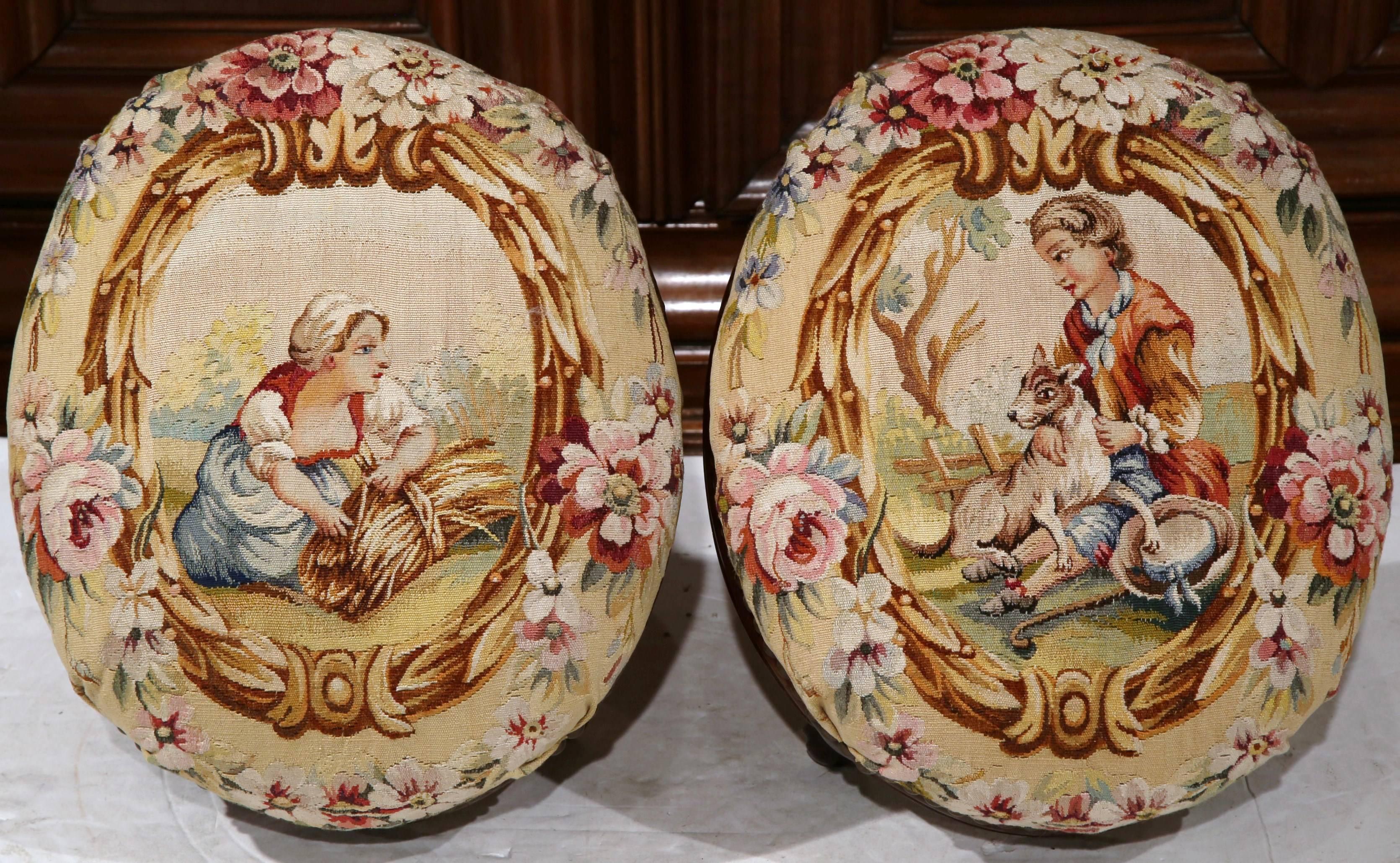 Incorporate neoclassical beauty into your home with this exquisite pair of colorful Napoleon III carved bombe footstools. Crafted in Paris, circa 1860, and made in mahogany wood, these oval stools have small scroll feet, and are upholstered with
