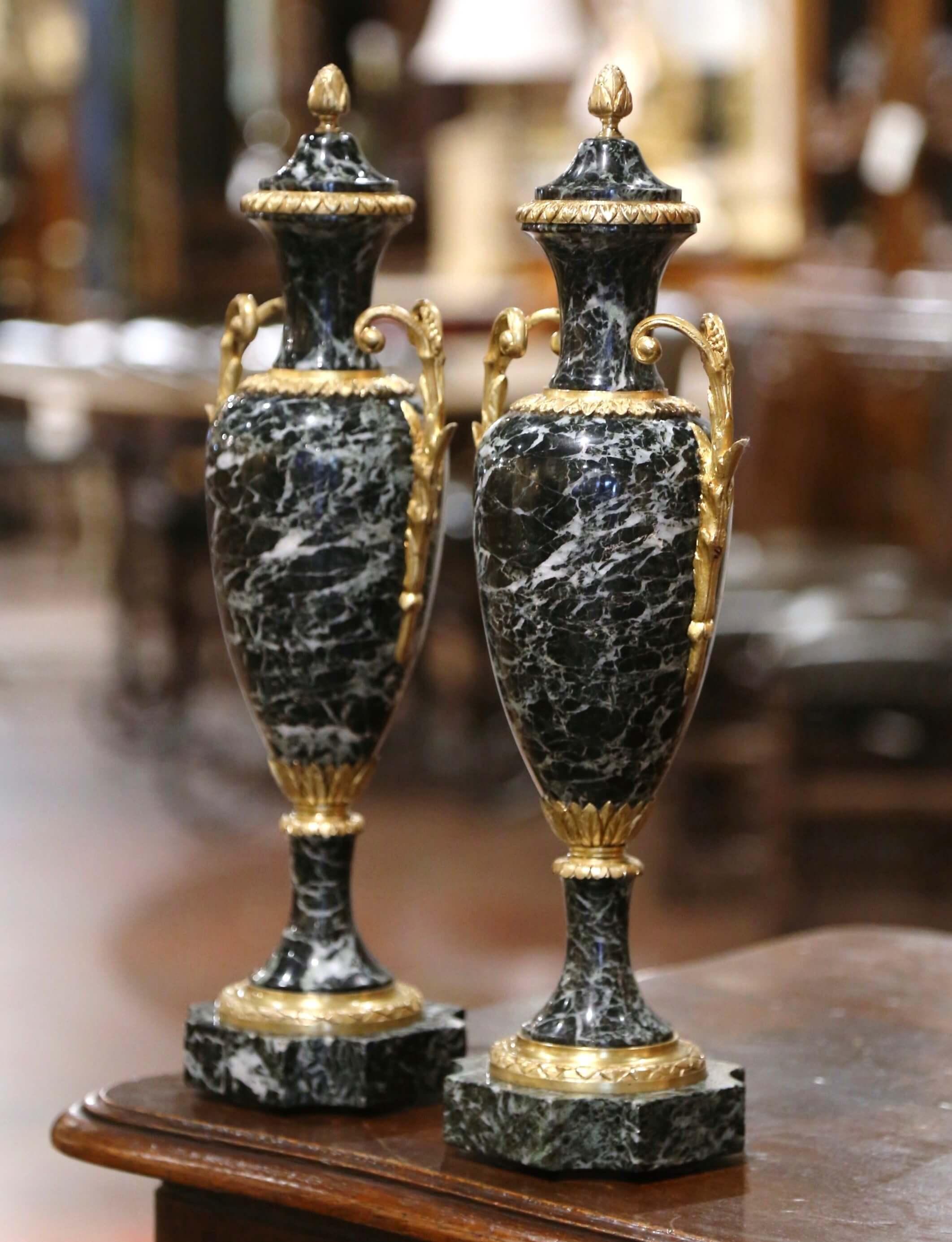 Decora una repisa o una consola con este elegante par de cassolettes de bronce dore antiguo y mármol. Fabricadas en Francia hacia 1890, estas urnas se apoyan en bases cuadradas de mármol con esquinas rebajadas. Cada recipiente, de mármol blanco y