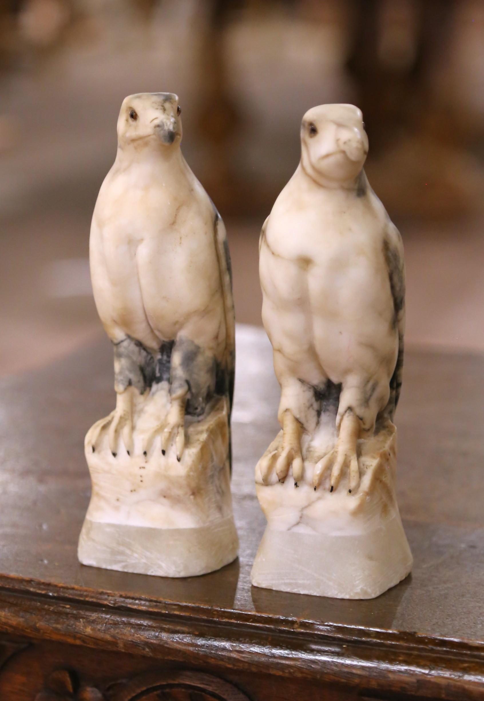 Crafted in France circa 1880, this charming pair of hand-carved marble eagles captures the majesty of these birds of prey in a compact and highly decorative form. Each sculpture is rendered from creamy variegated marble with dramatic gray veining,