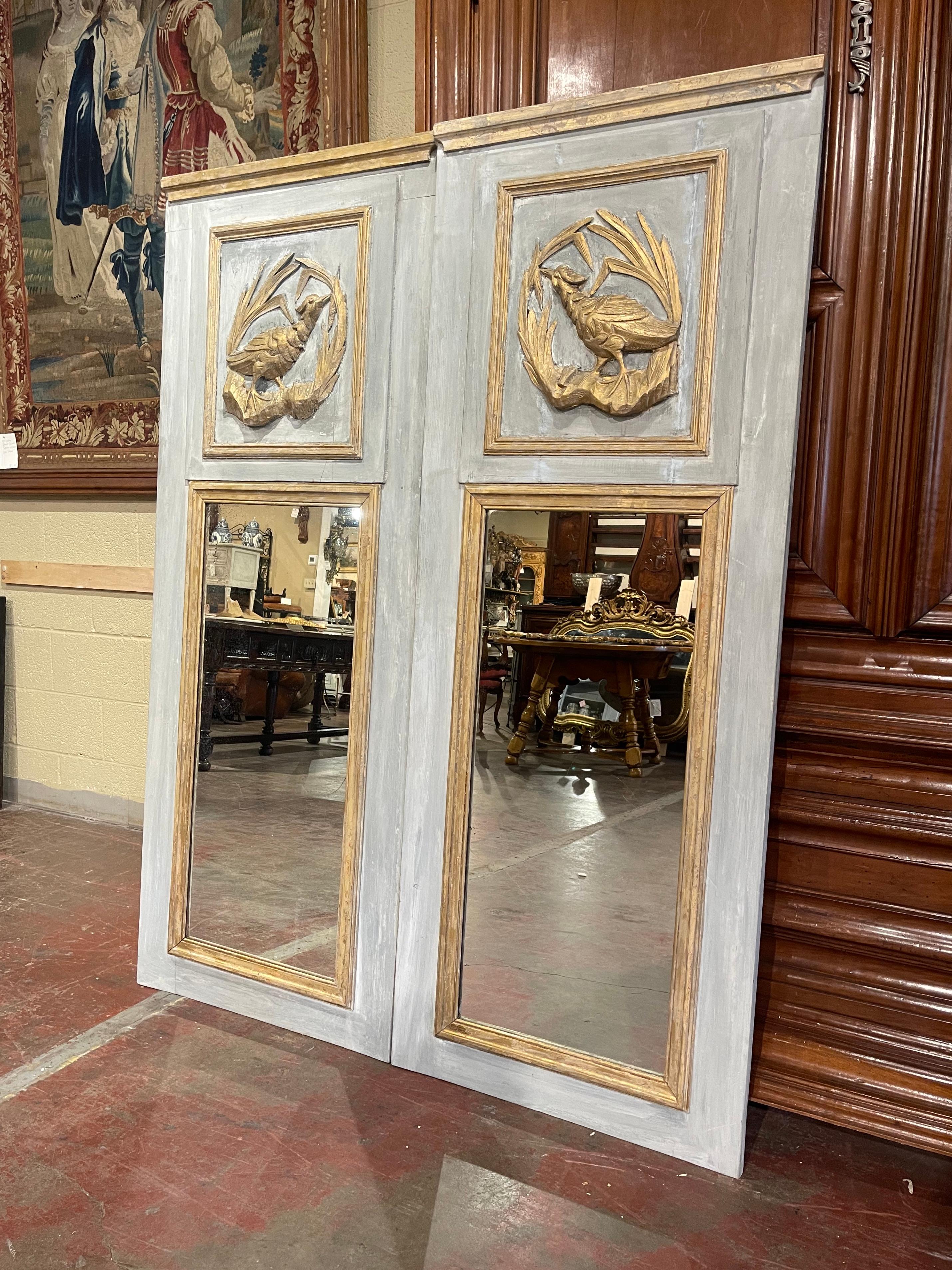 Decorate a living room, or an entry with this elegant pair of colorful trumeaux mirrors. Crafted in Normandy France, circa 1950, each trumeau is dressed at the pediment with a gilt crown and features a hand carved bird motif in high relief; it