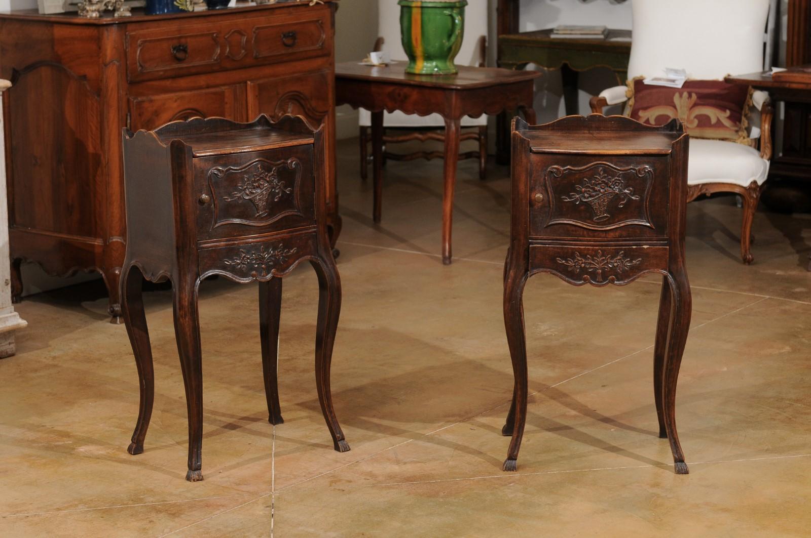 A pair of French walnut tables de chevet from the 19th century, with carved foliage and cabriole legs. Created in France during the 19th century, each of this pair of bedside tables features a rectangular top surrounded by a curving three-quarter