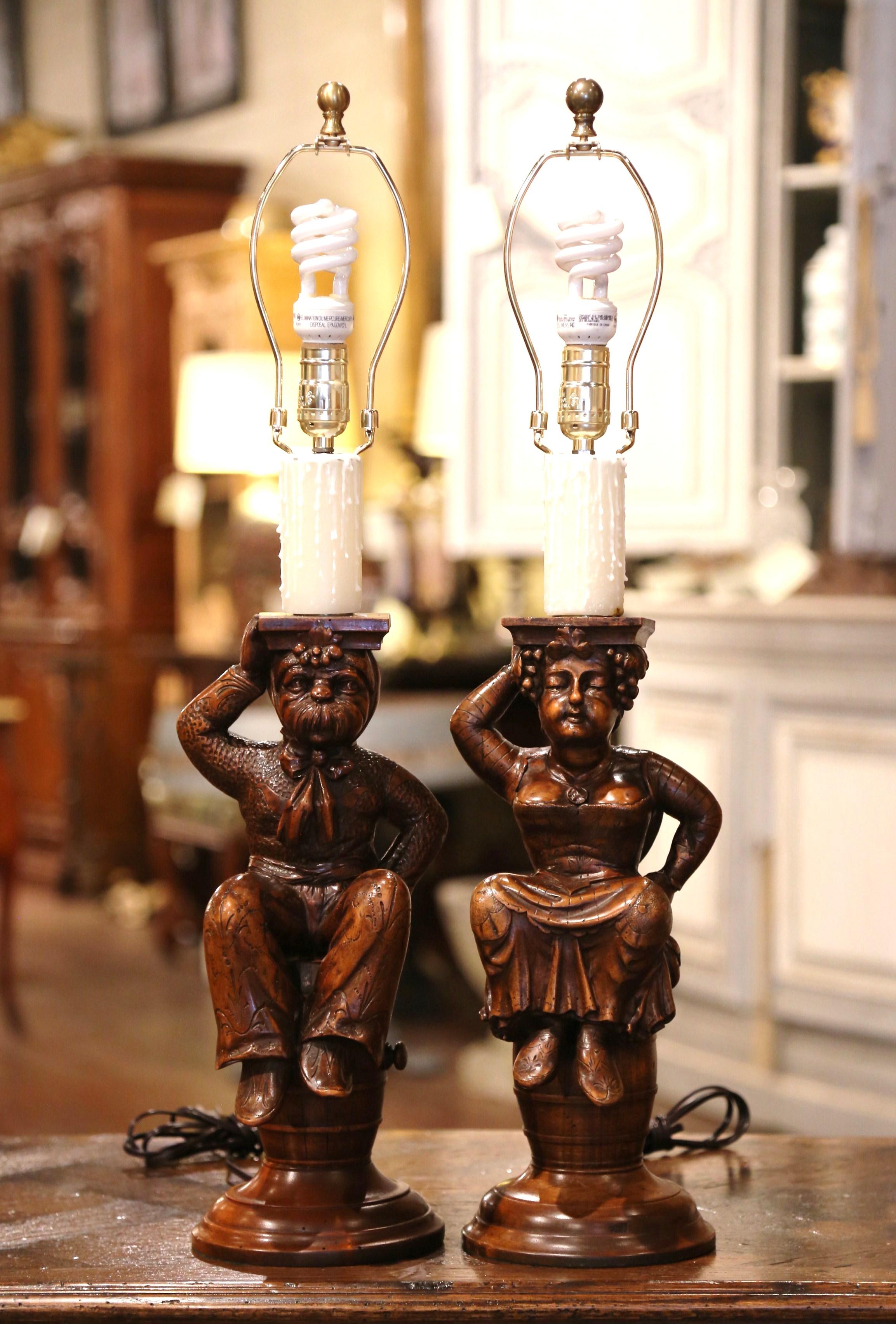 Decorate a wine cellar or a bar with this pair of antique cabaret lamp bases. Crafted in France circa 1880, each sculpture stands on a round base and features a carved male and female cabaret characters sited on a round whisky or wine barrel. Each
