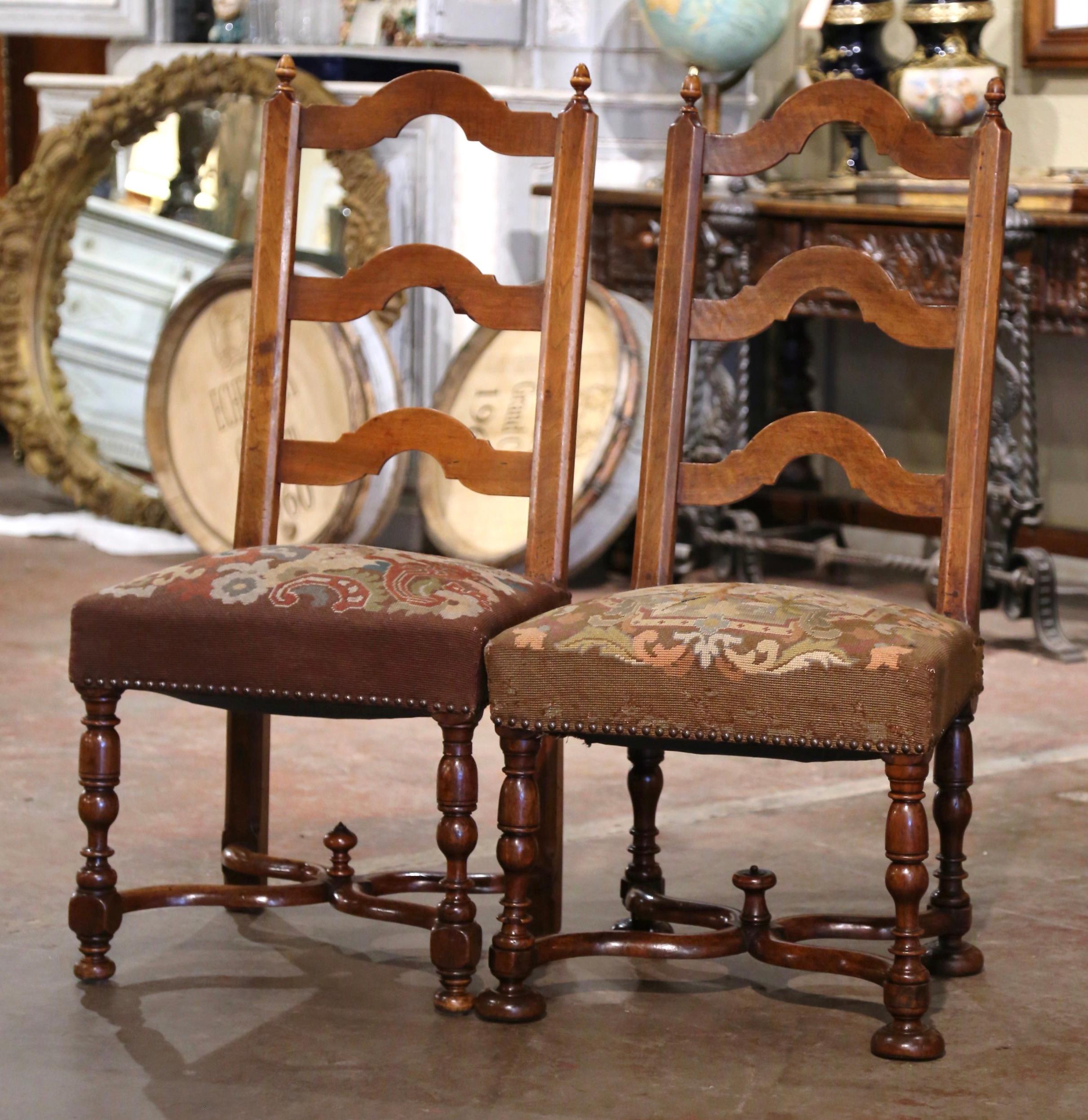 Decorate a bedroom or study with this elegant pair of antique side chairs. Crafted in southern France circa 1870, each chairs stands on turned legs ending with bun feet over a carved X stretcher embellished with a center finial. The tall and pitched