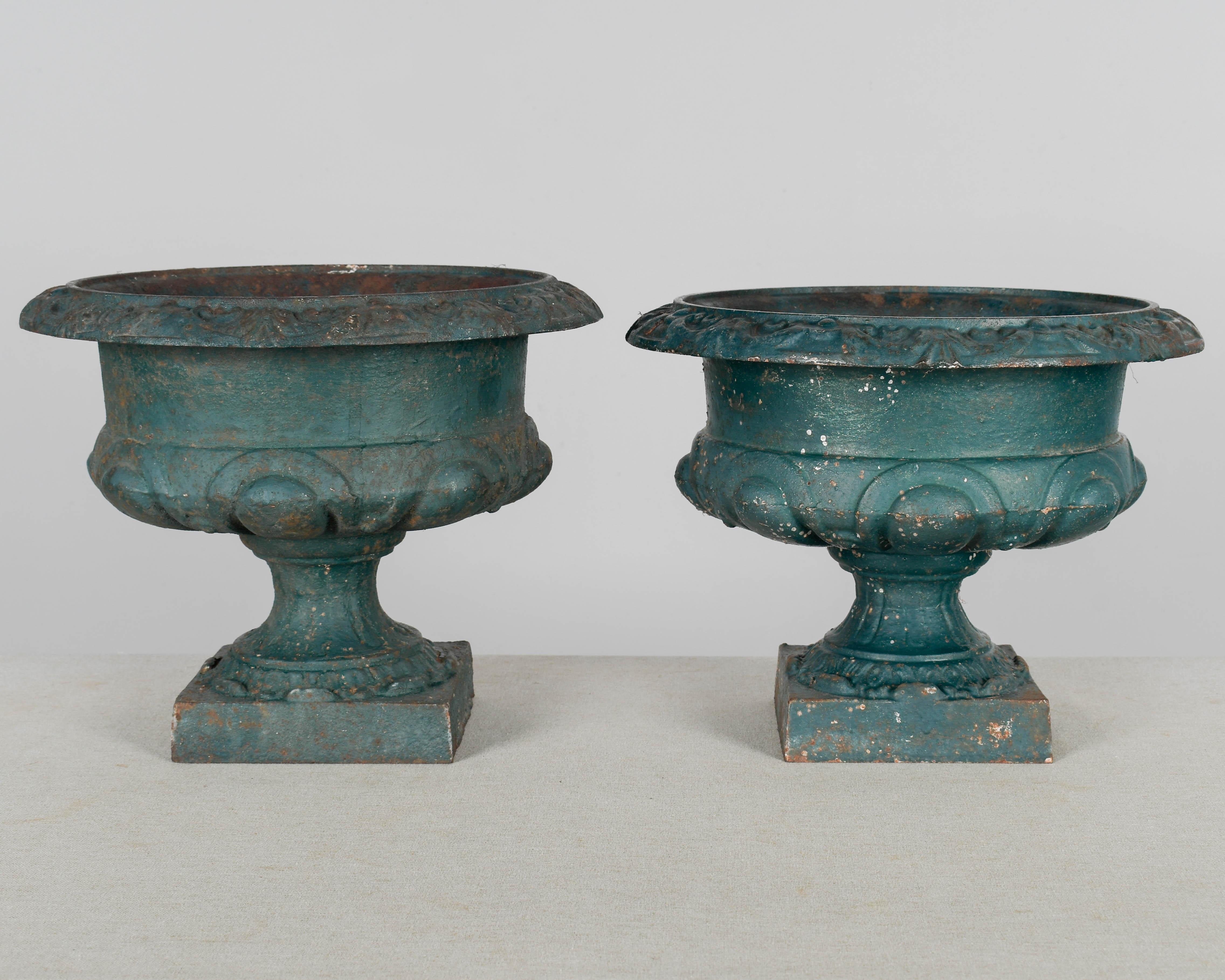 Coppia di fioriere da giardino in ghisa dipinte di verde del XIX secolo. Bella patina arrugginita dalle intemperie con qualche perdita di vernice. Circa 1880-1900. 
Peso: 21 libbre ciascuno
10 