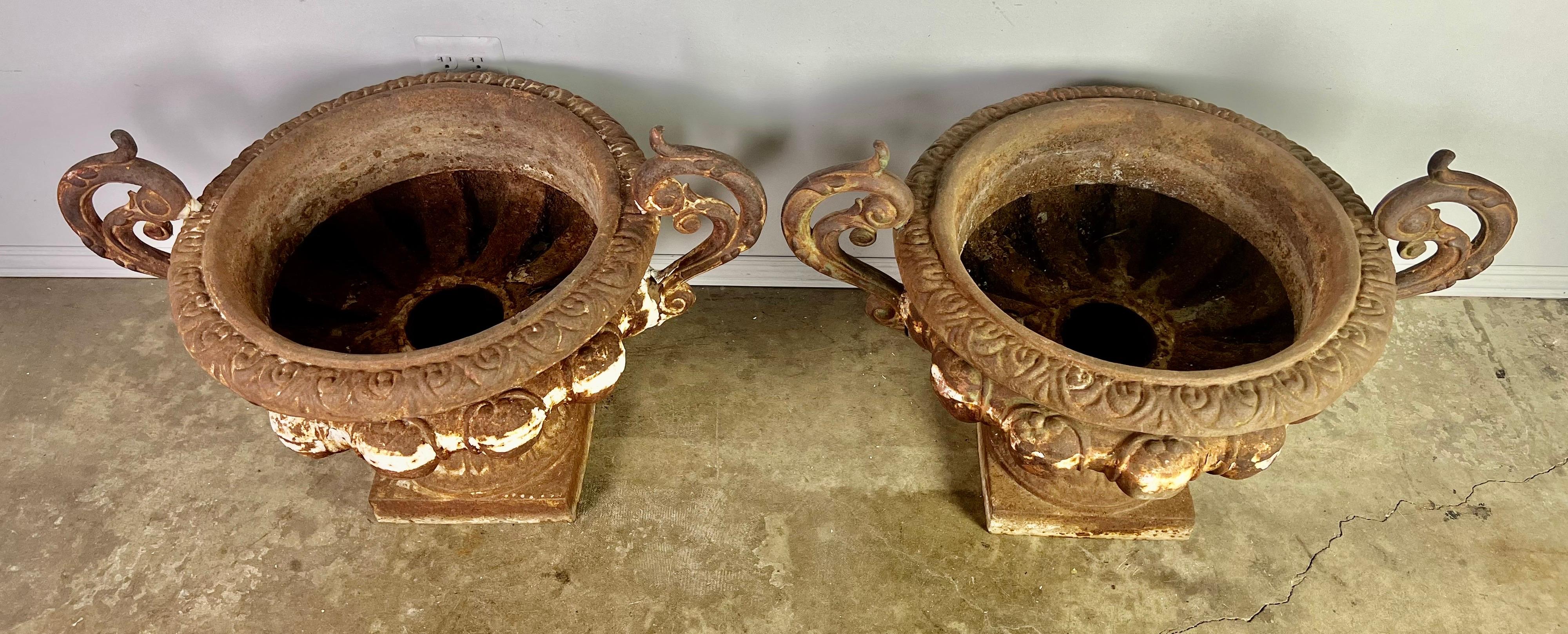 Pair of 19th century French cast iron planters with years of wear to their beautiful patina. Great overall condition with drain holes.
