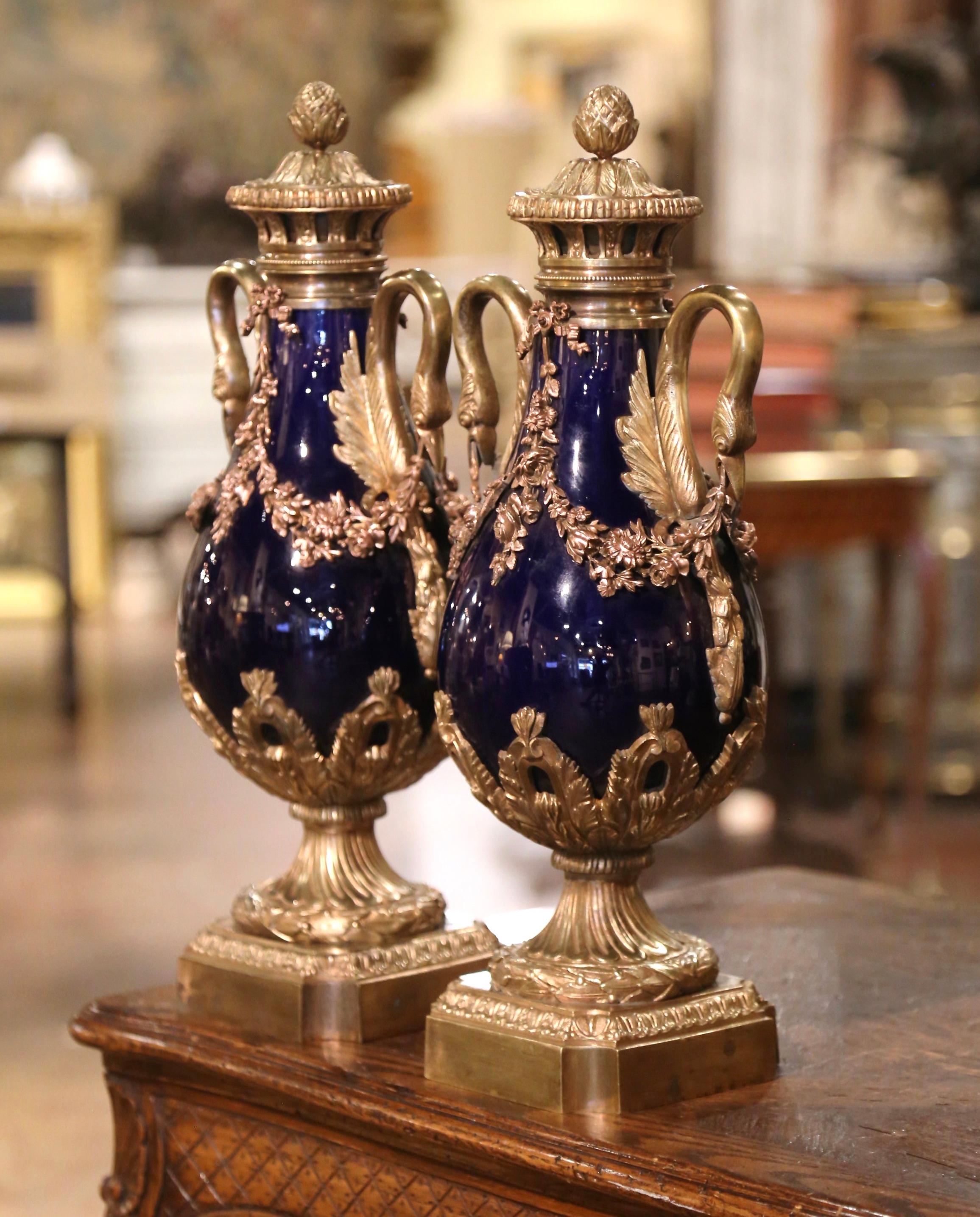 Dekorieren Sie einen Kaminsims oder eine Konsole mit diesem bunten Paar antiker Kassetten. Die um 1870 in Frankreich gefertigten Urnen bestehen aus Porzellan und stehen auf einem quadratischen Bronzesockel mit abgeschnittenen Ecken, die mit