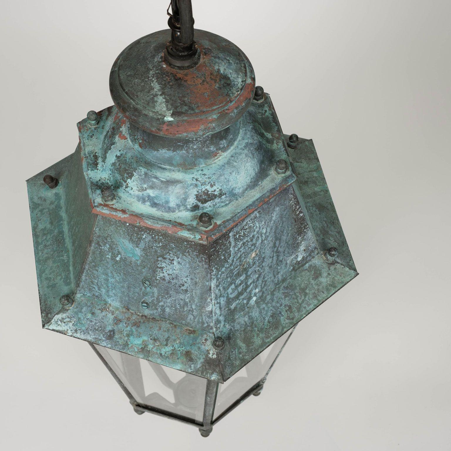 Pair of 19th century French Copper and glass paneled lanterns circa 1865-1884. Blue-green verdigris patina. Originally served as a gas-lit street lanterns - now newly-wired with a drop-cluster of three candelabra lights each. Includes four feet of