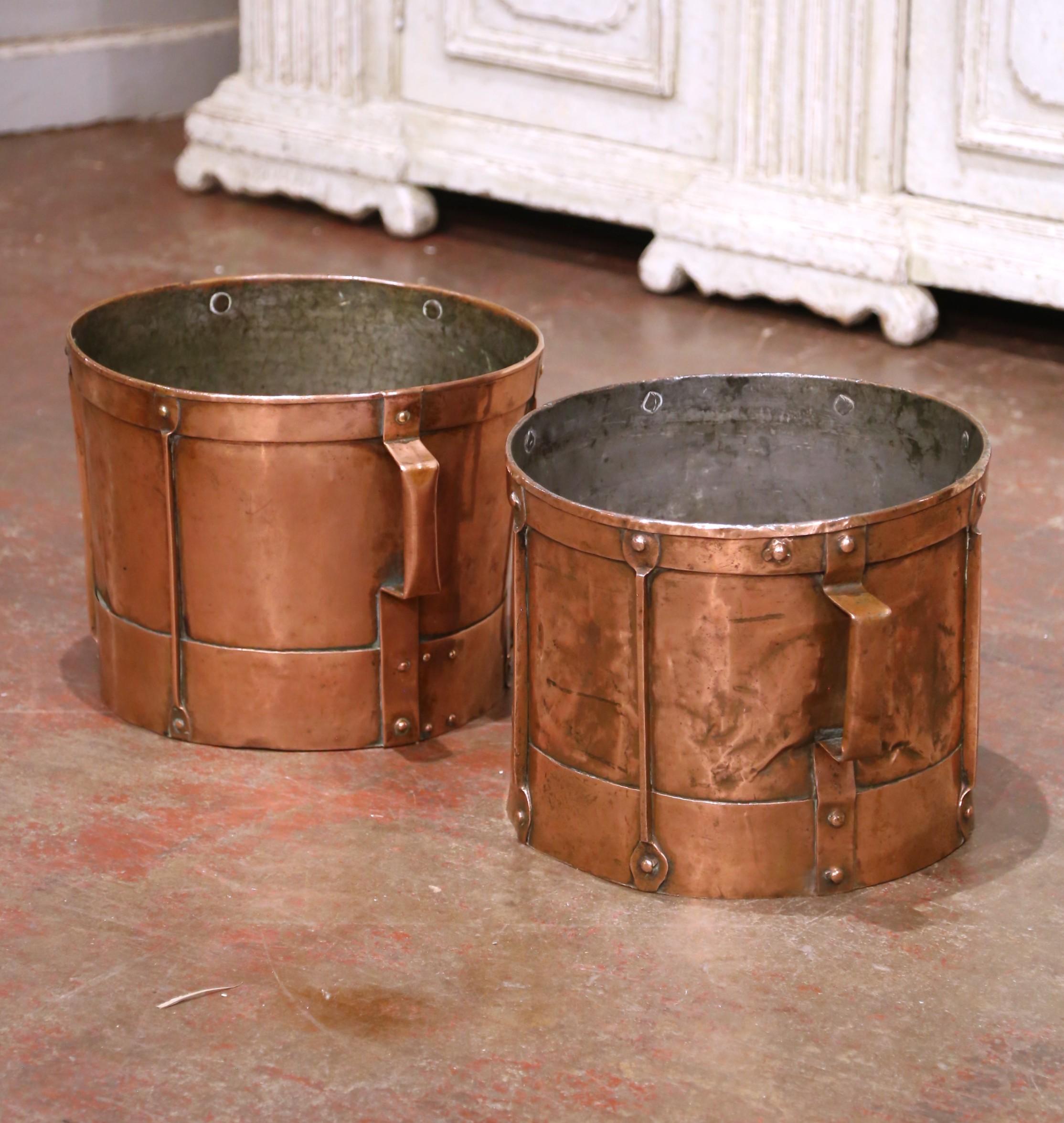 This pair of antique grain measuring recipients were crafted in France, circa 1870. The buckets feature copper strapping motifs, forged nails on the outside and two side handles. The measuring tools are in excellent condition, and have a rich copper