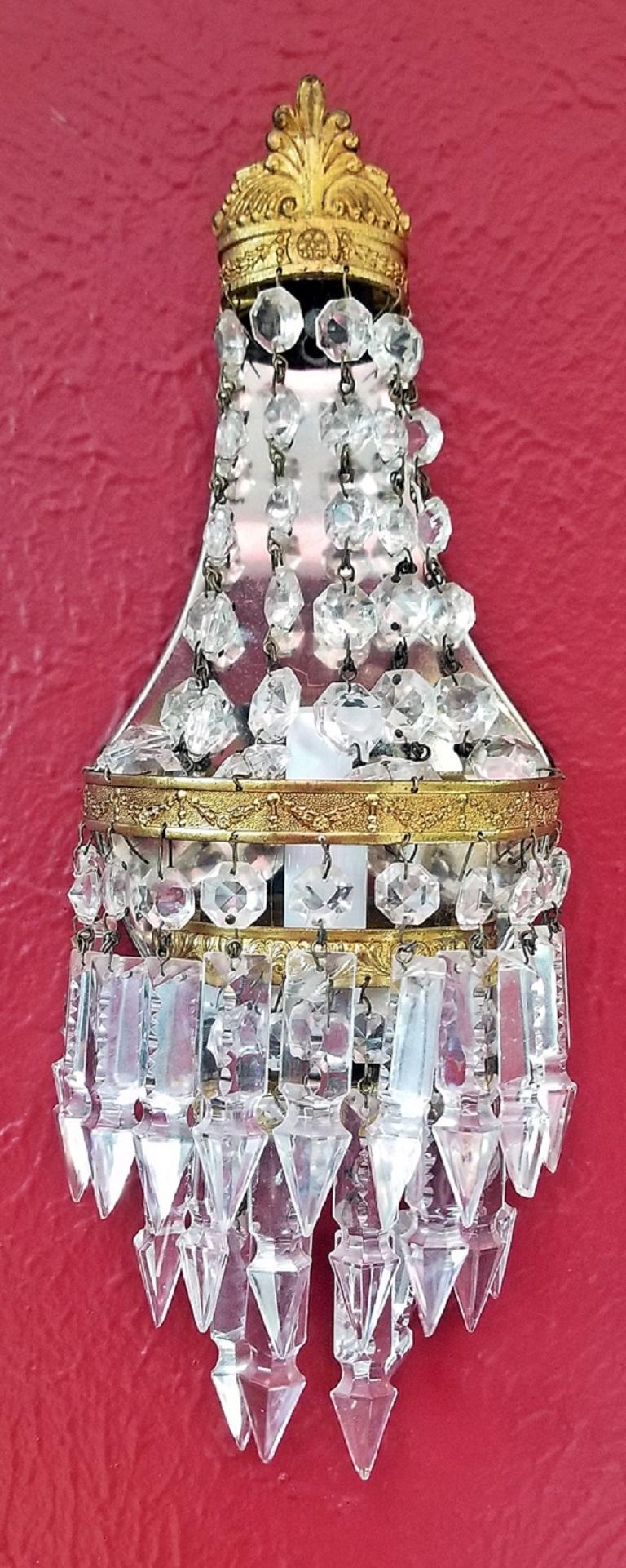 Lovely pair of 19th century French bead crystal wall lights or sconces in Louis XVI style,
circa 1890.

Ormolu mounts, crown effect on pelmet, crystal string beads on main section. Mirrored back to reflect light. Bottom section is made of hanging