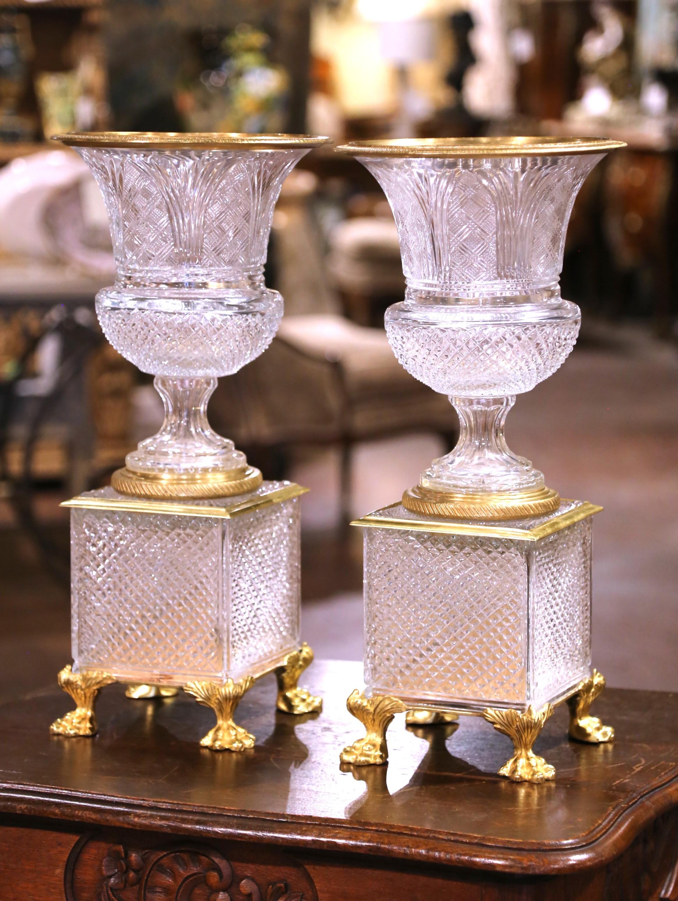 Cette élégante paire de vases de garniture anciens a été fabriquée en France vers 1880 et témoigne de l'art raffiné du XIXe siècle en cristal taillé et en bronze doré, dans le style de Baccarat ou de Saint Louis. Chaque récipient présente une lèvre