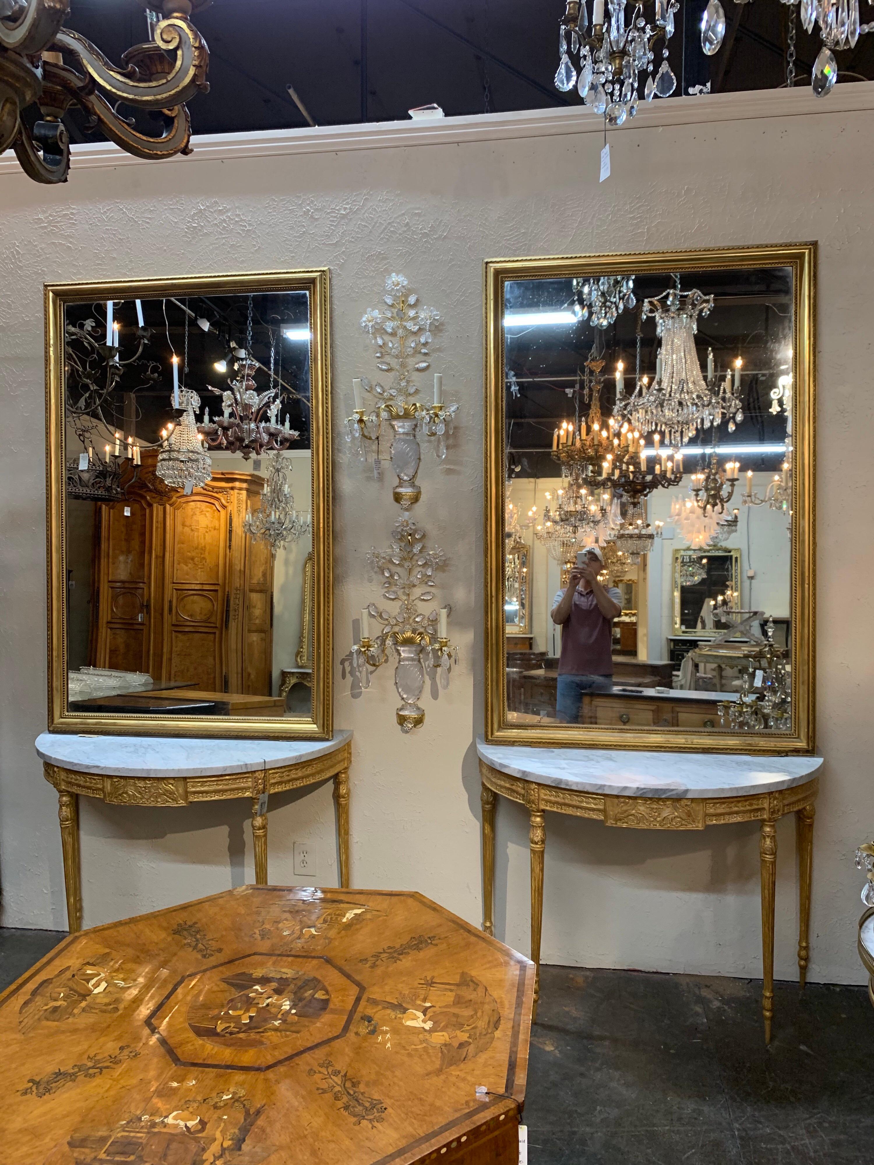 Very fine large pair of 19th century French Directoire style giltwood mirrors. Beautiful gilt on these along with pretty details on the borders. A great pair that would make a stunning statement!