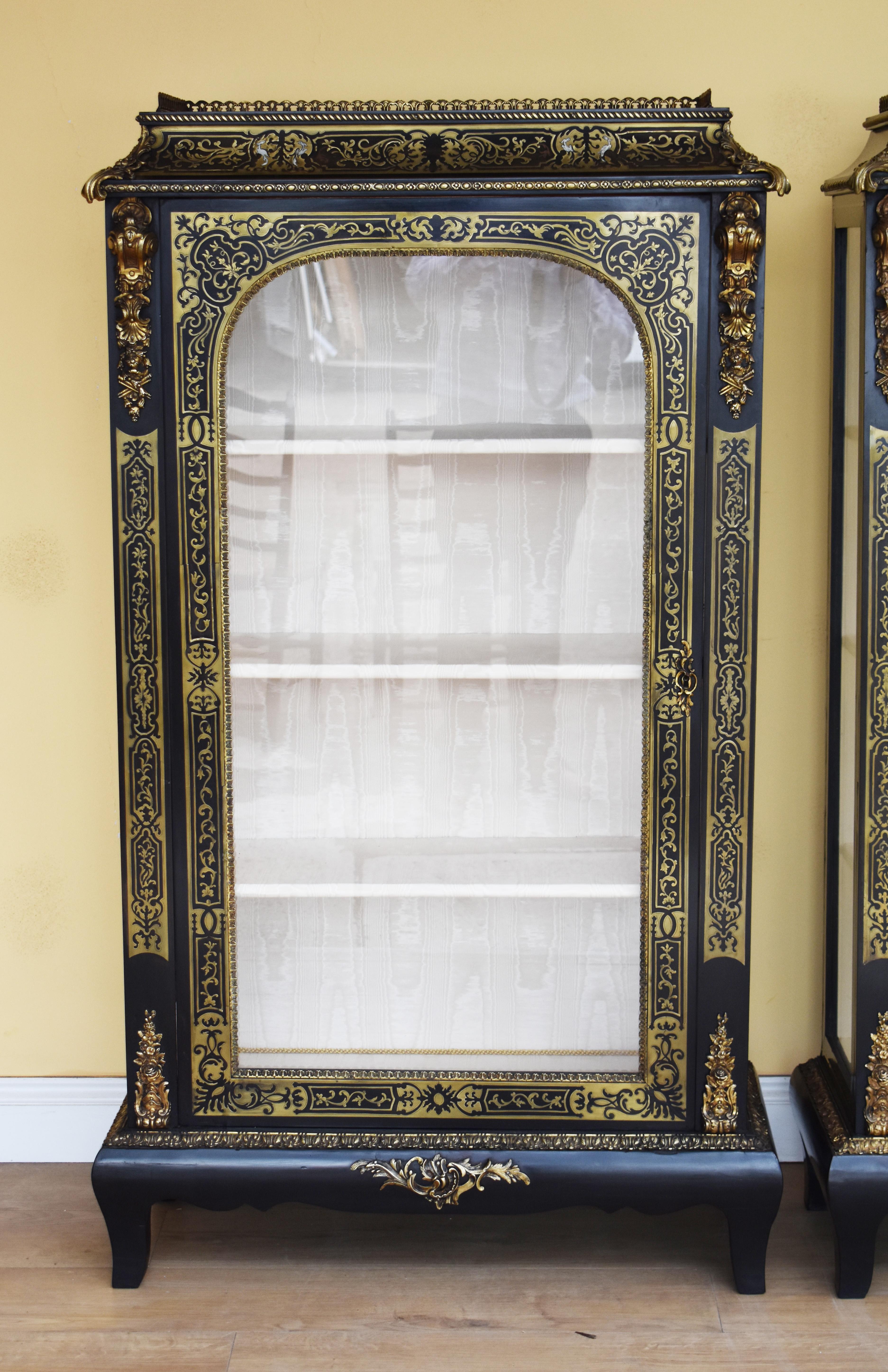 For sale is a good pair of 19th century Victorian ebonized Boulle cabinets. Each cabinet has a brass gallery to the top, with a single glazed door below. Each door is surrounded by intricate brass inlay and also has decorative mounts to the top and