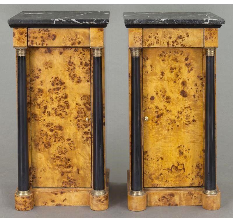 These elegant, antique bedside tables were created in France, circa 1890. Both matching cabinets are made of elm wood; they have a recessed center door flanked by a pair of round, ebonized columnar supports decorated with brass rings both at the