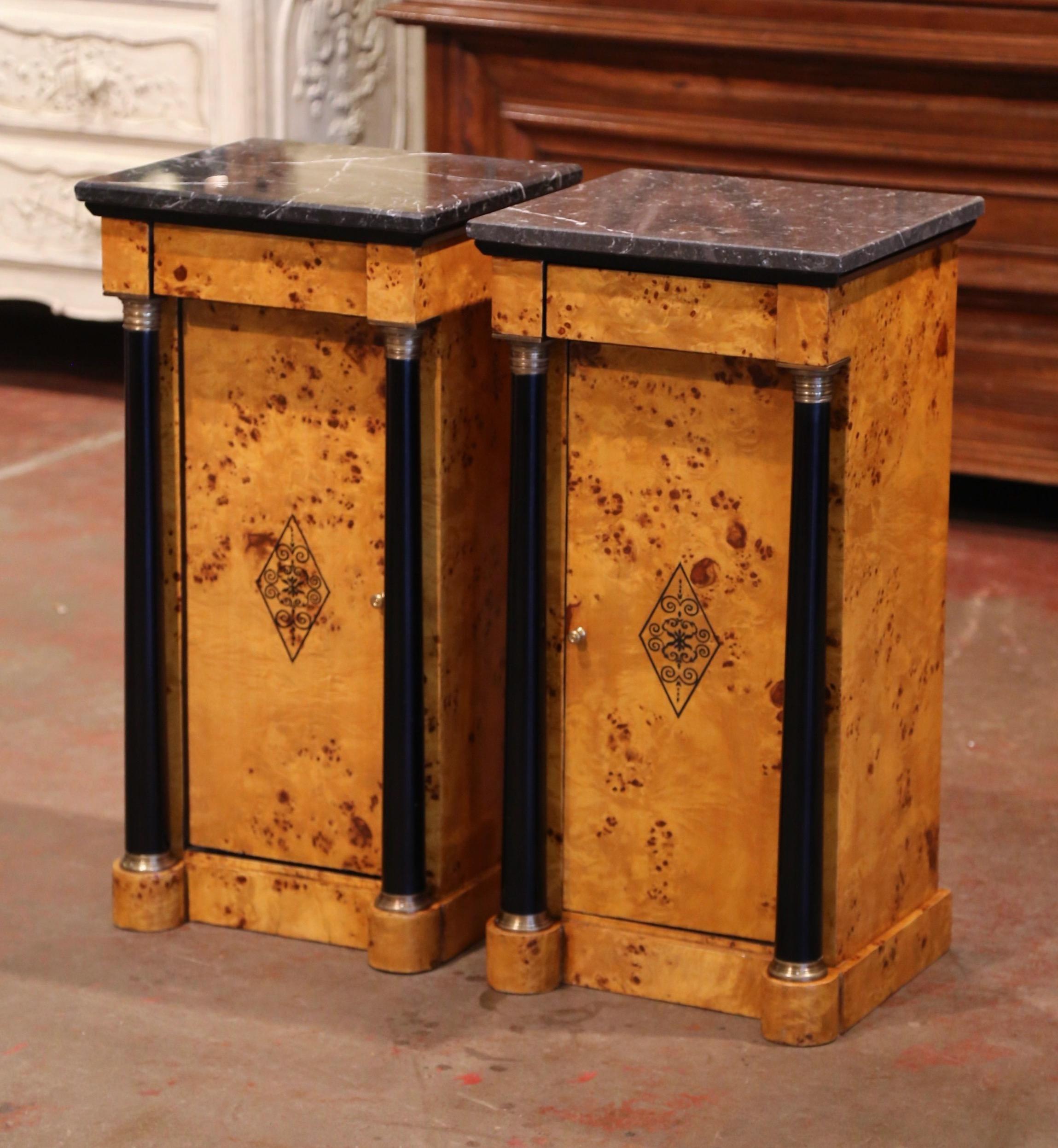 These elegant, antique bedside tables were created in France, circa 1890. Both matching cabinets made of elm wood stand on a thick plinth base; they feature a recessed center door decorated with a central motif, and are flanked by a pair of round,