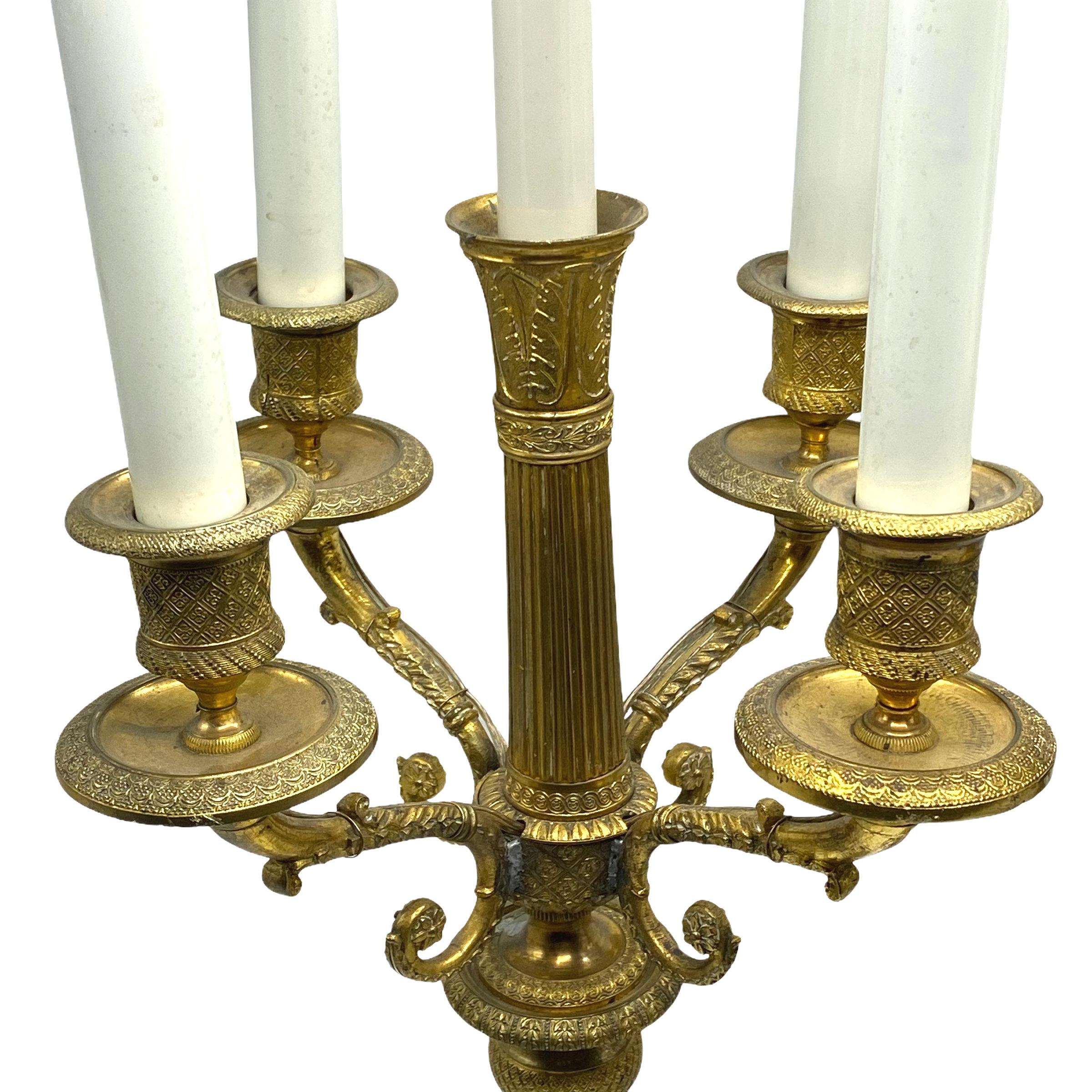 pair of 19th Century French Empire Gilt Bronze Candelabra Lamps in  Charles X style, later electrified in the late 19th to early 20th century, with candelabra size sockets and circular on/off switches installed at the bases.
