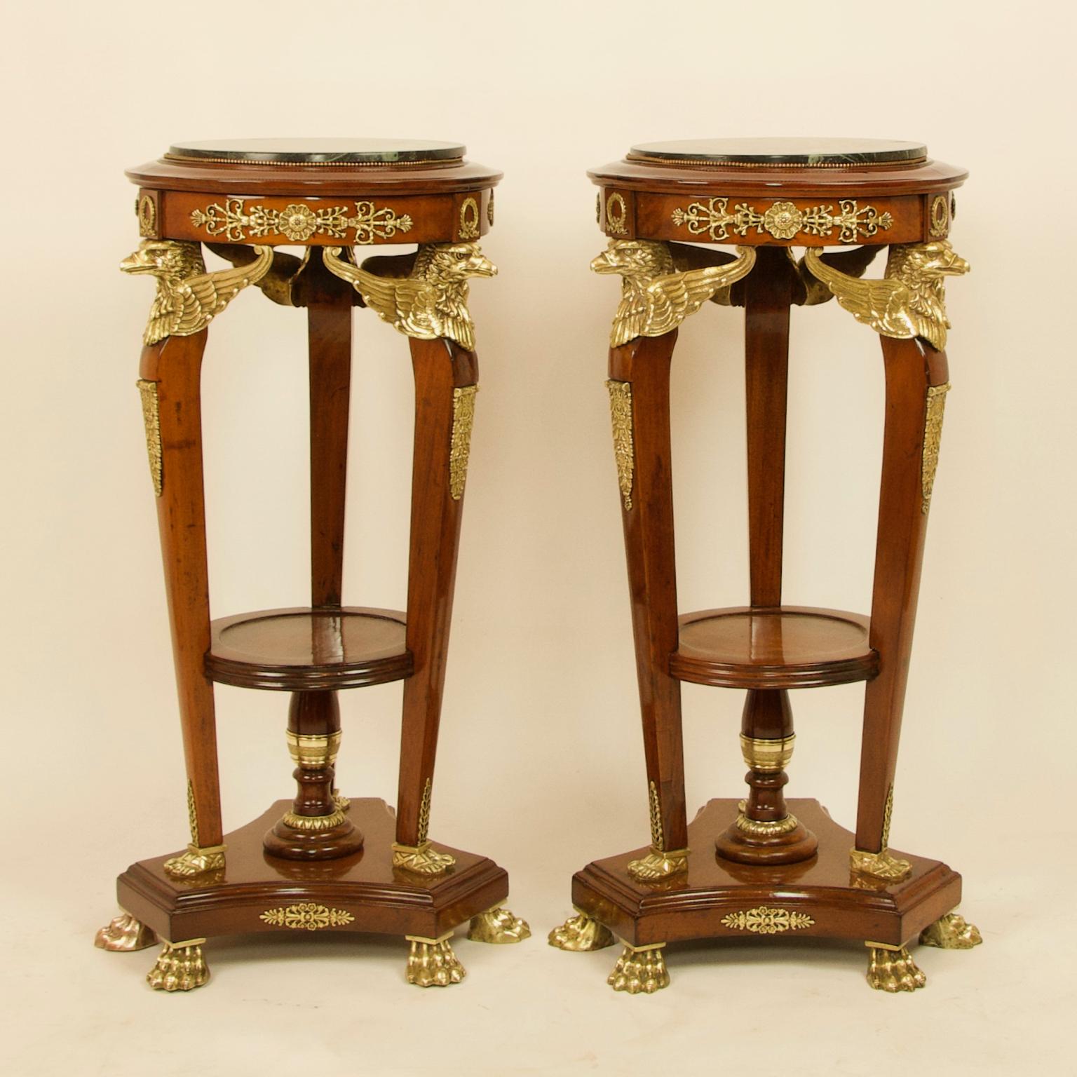 Pair of 19th century French Empire walnut bronze eagle heads pedestals/stands

Standing on a triform base with gilt bronze lion paw feet, three slender and tapering legs each topped with a gilt-bronze winged eagles' head and ending in a bronze pair