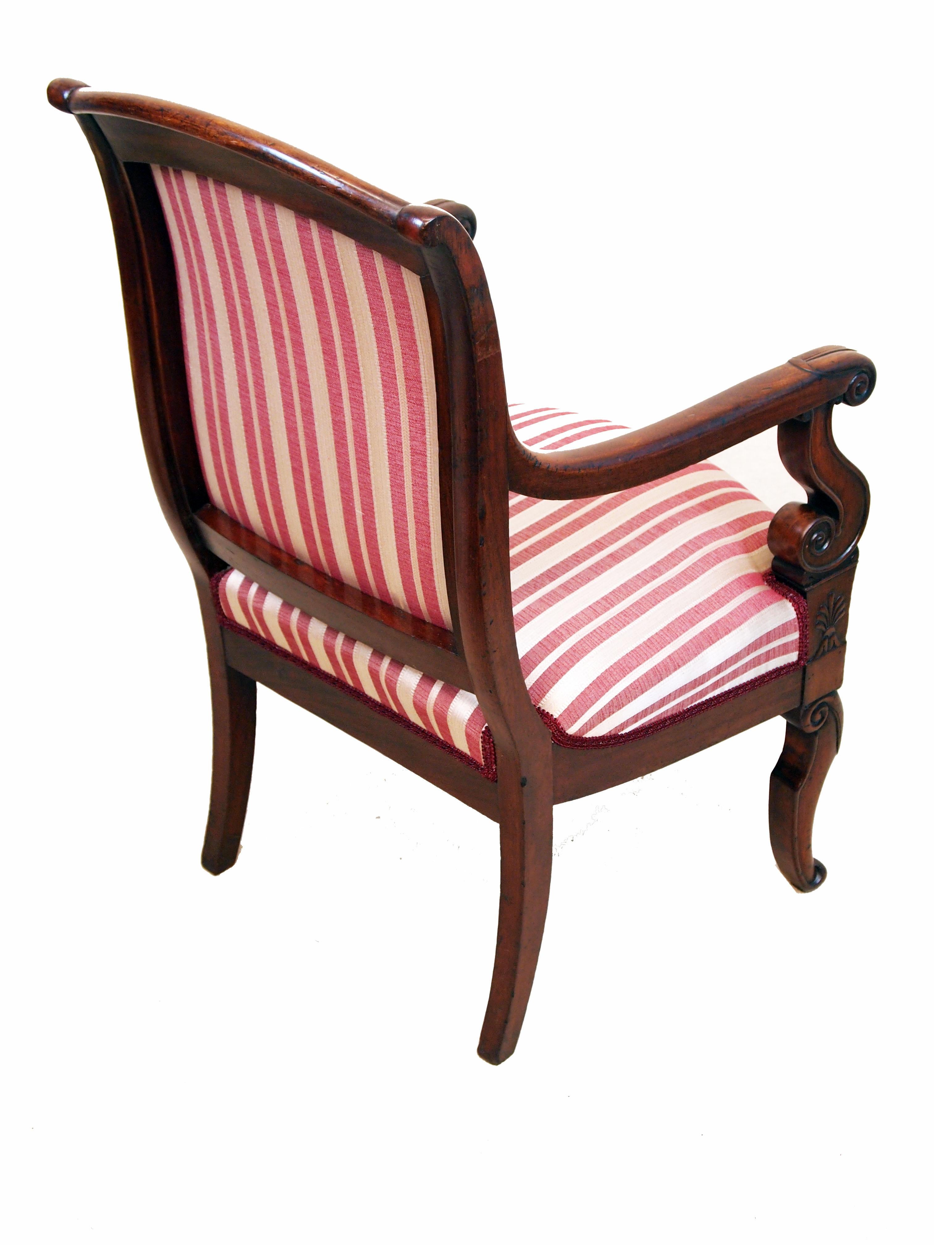 An excellent quality pair of 19th century mahogany
library armchairs, in the French empire taste, having
swept back and moulded scrolling arms with C-scroll
supports raised on elegant moulded sabre legs

(A relative typical design in the early