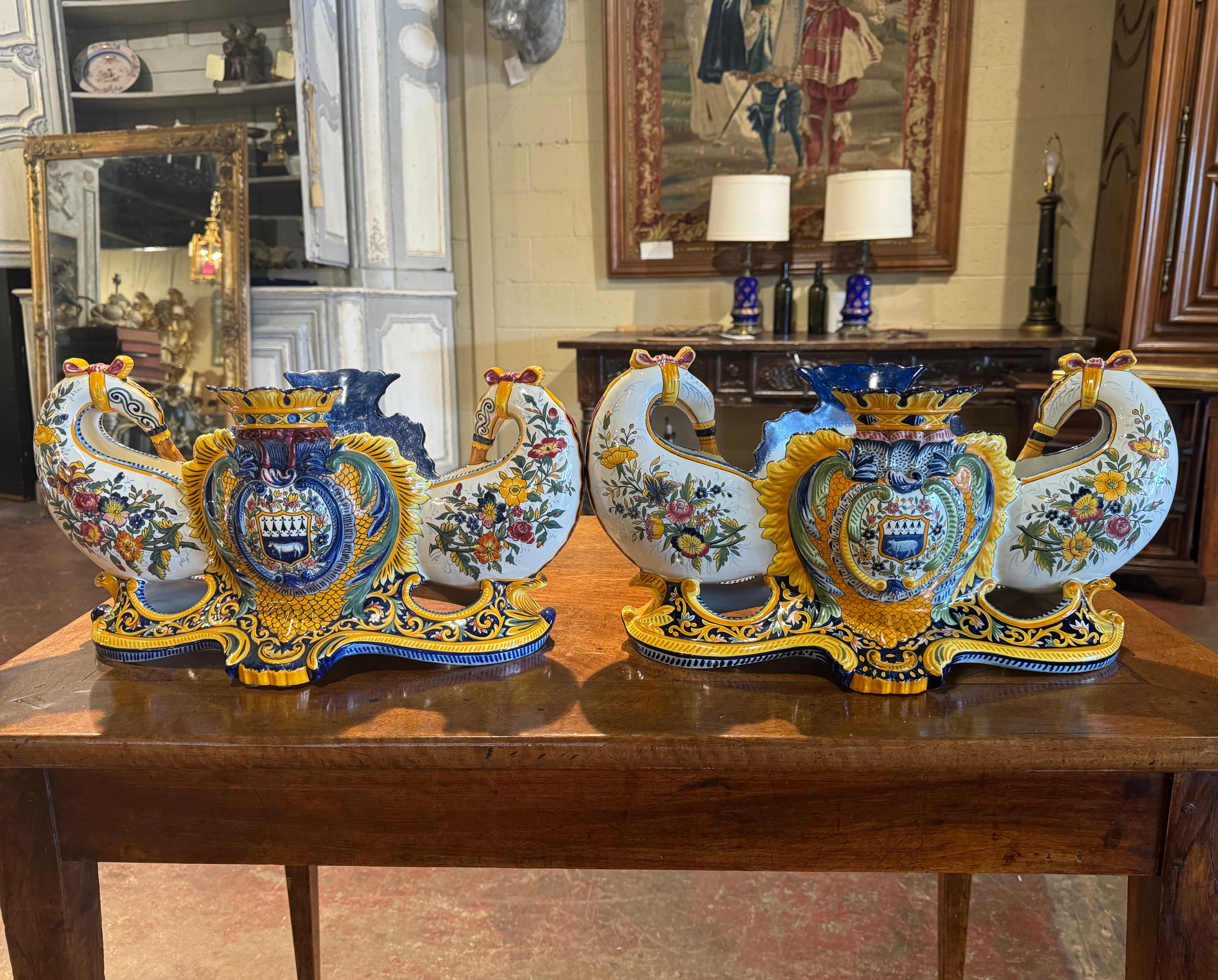 Decorate a dining table or buffet with this elegant and colorful antique pair of jardinieres. Sculpted in Brittany, France, circa 1880, the uniquely oblong shaped planters with double- bagpipe handles, are decorated with hand painted center