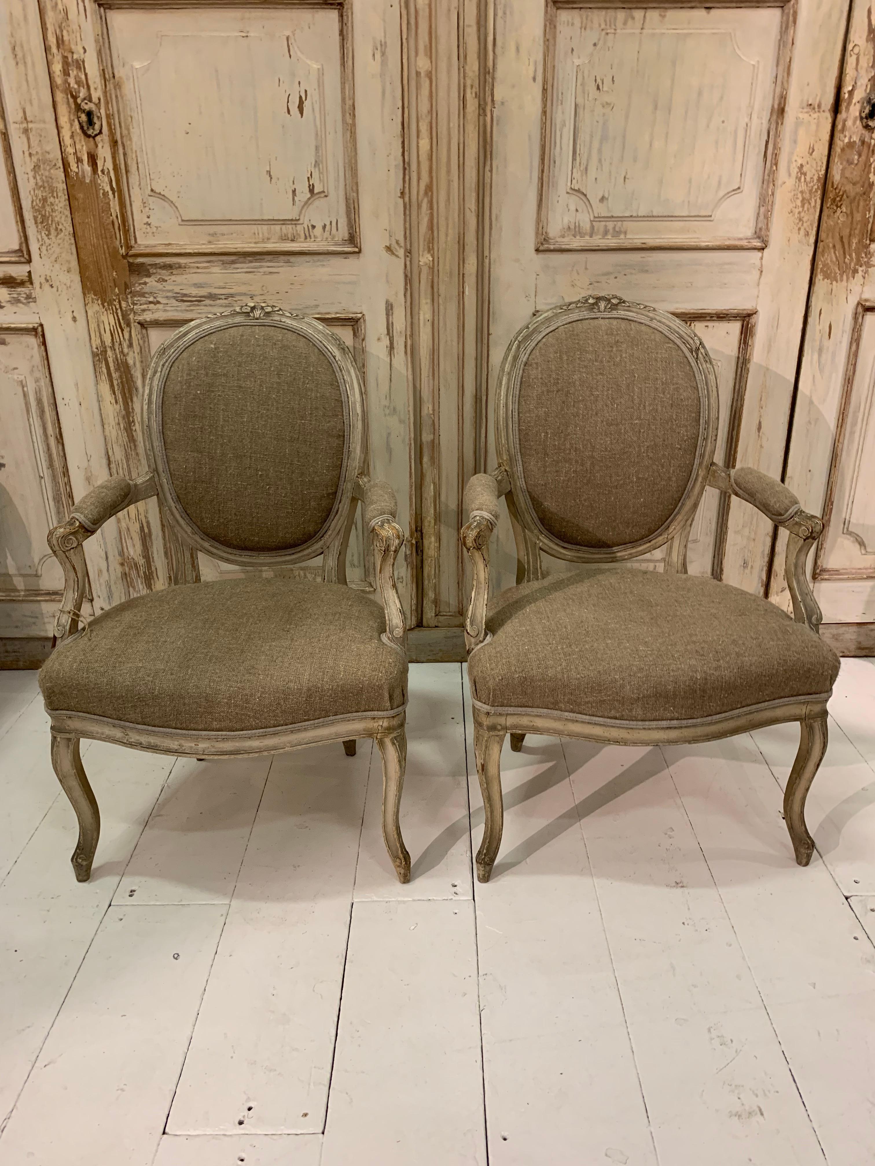 A lovely pair of late 19th century French open armchairs with carved detail and original paint.
The armchairs have been upholstered in hungarian linen and would work well as a comfortable pair of side chairs and also a perfect addition in a bedroom.