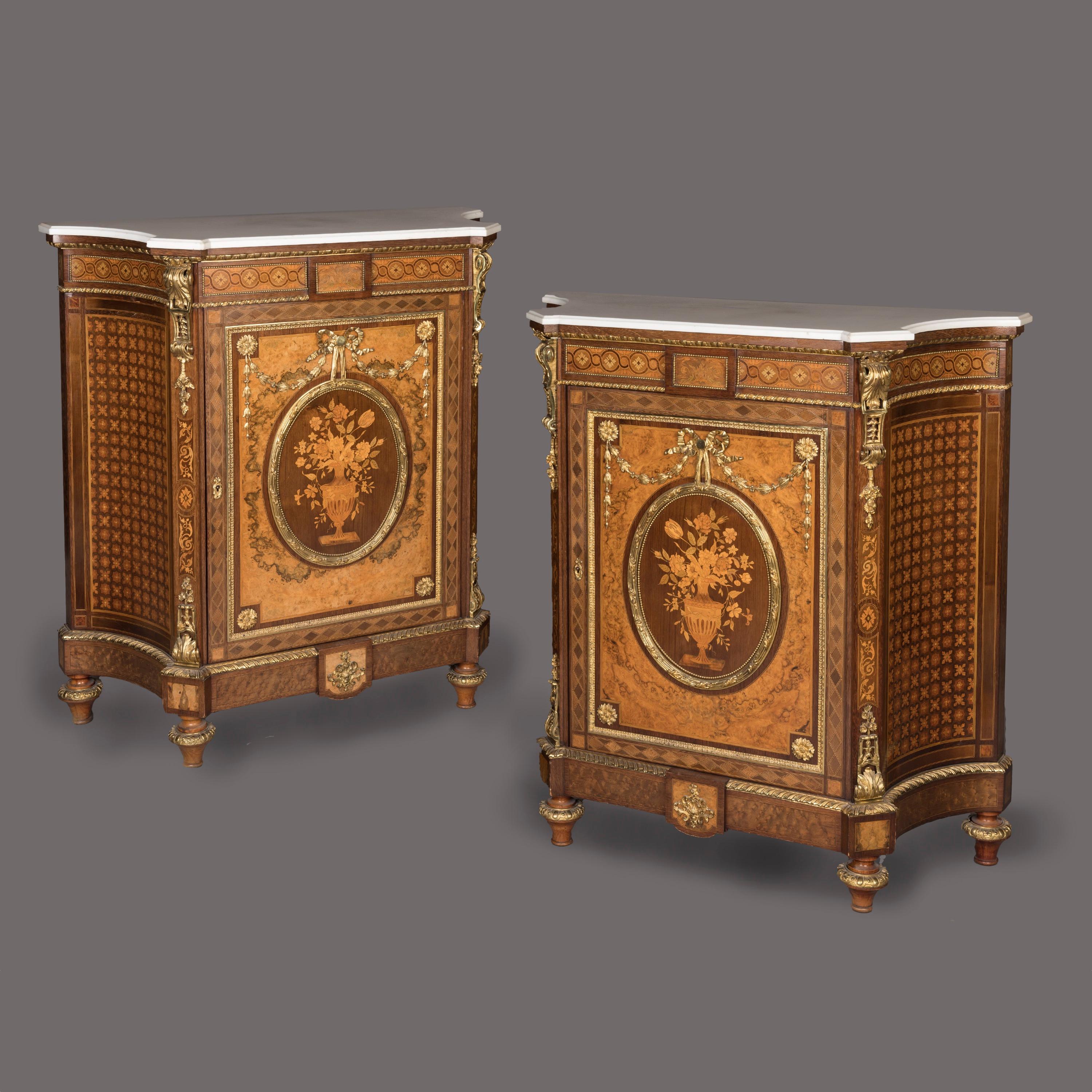 A Fine Pair of Louis XVI Style 
Marquetry Inlaid Meubles d'Appui

Constructed from a striking burr walnut, with marquetry inlays of various specimen woods including harewood, boxwood and sycamore, with amaranth crossbanding and decorated with ormolu