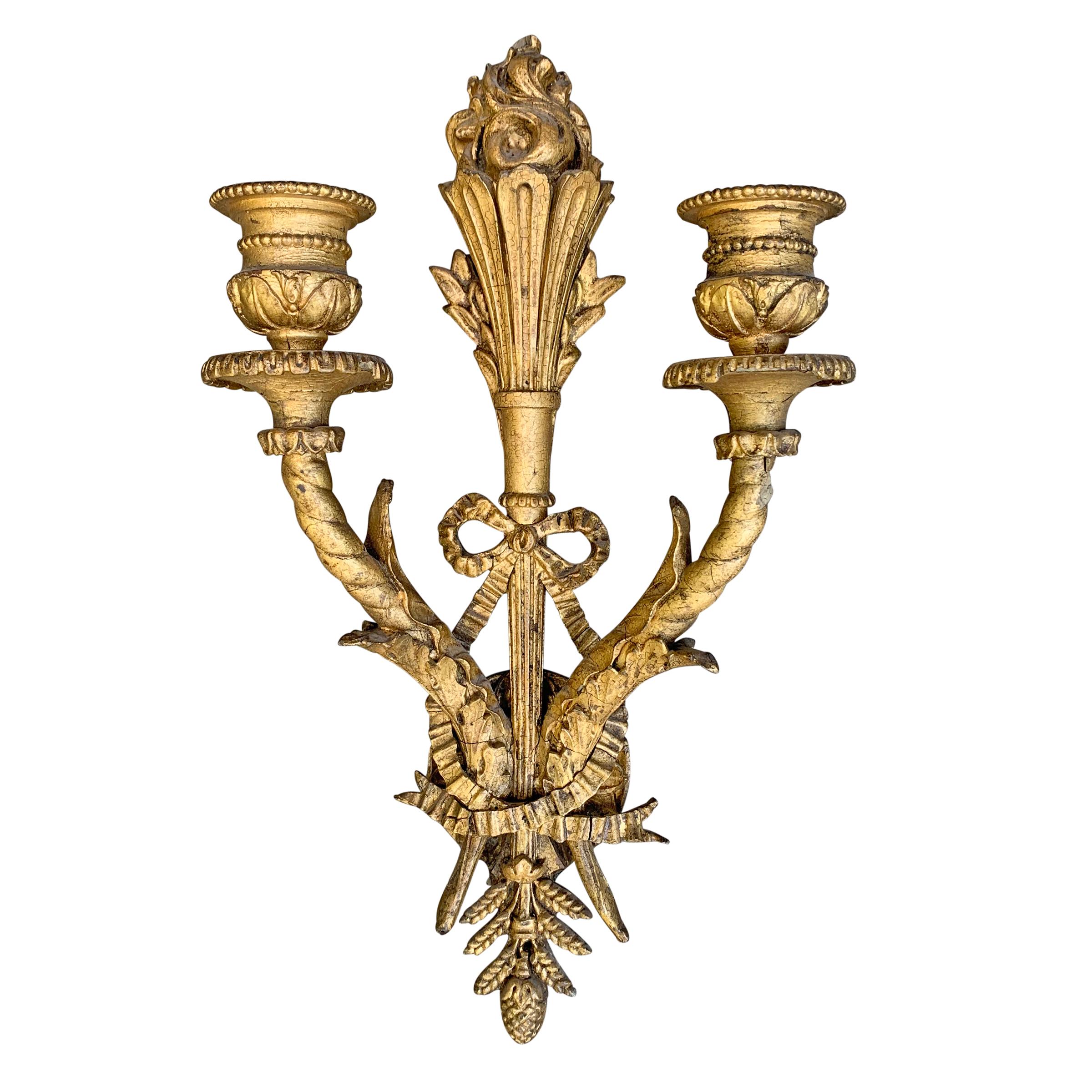 A pair of wonderful 19th century French giltwood and composition sconces with a central torch holding a large flame and two scrolled arms with acanthus leaves and a bow and ribbon. Lights were once electrified, but will need to be rewired for use.