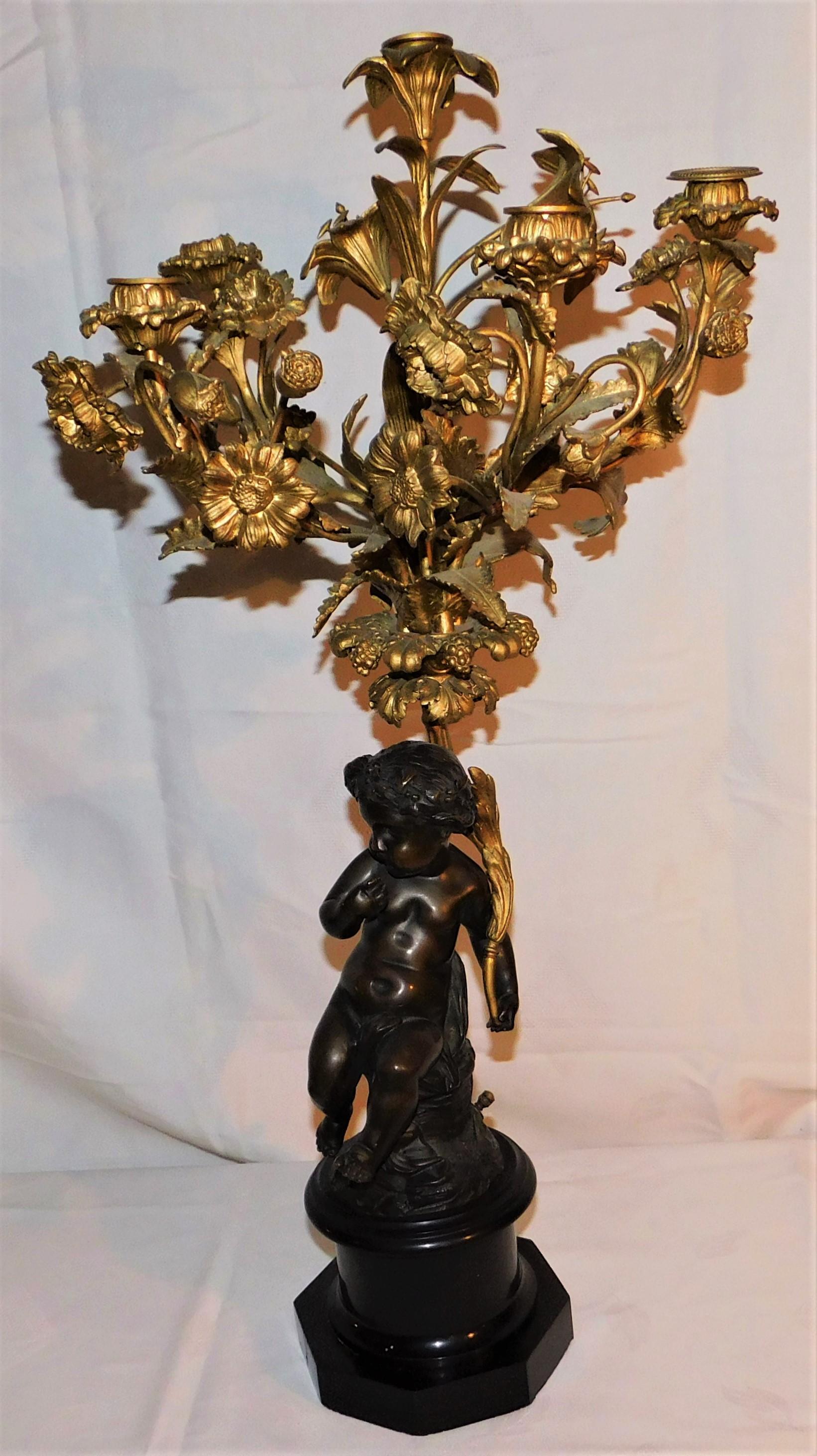 Gorgeous pair of French gold gilded bronze candelabras on a black granite base. Each piece has a five branch candle holder. The measurement are for each individual candelabra.

    