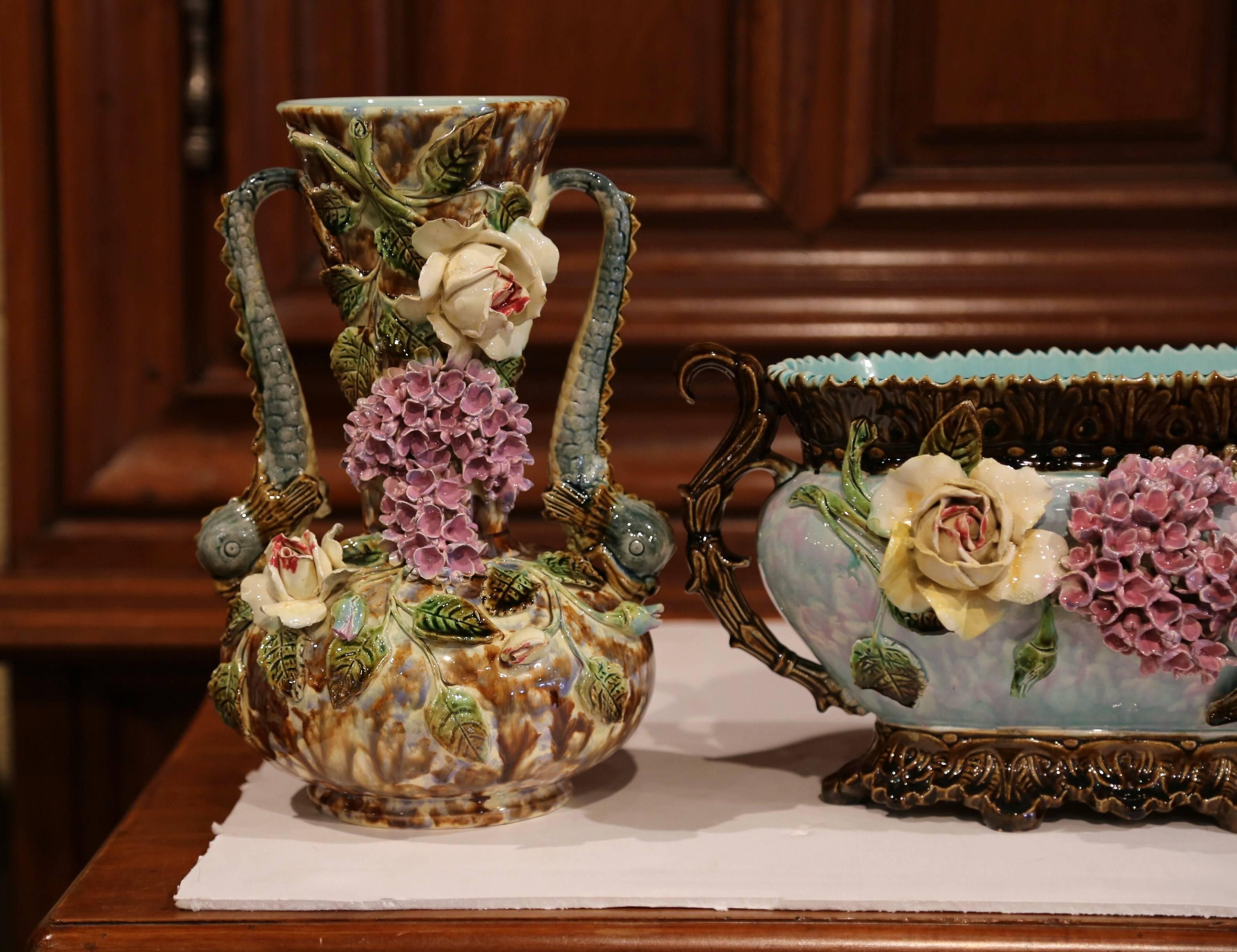 Beautifully sculpted and colorful, this set of antique Majolica vases and matching jardiniere would be a wonderful addition to a mantel, tabletop or bookshelf. Crafted in France, circa 1870, each hand-painted piece is covered with ornate floral