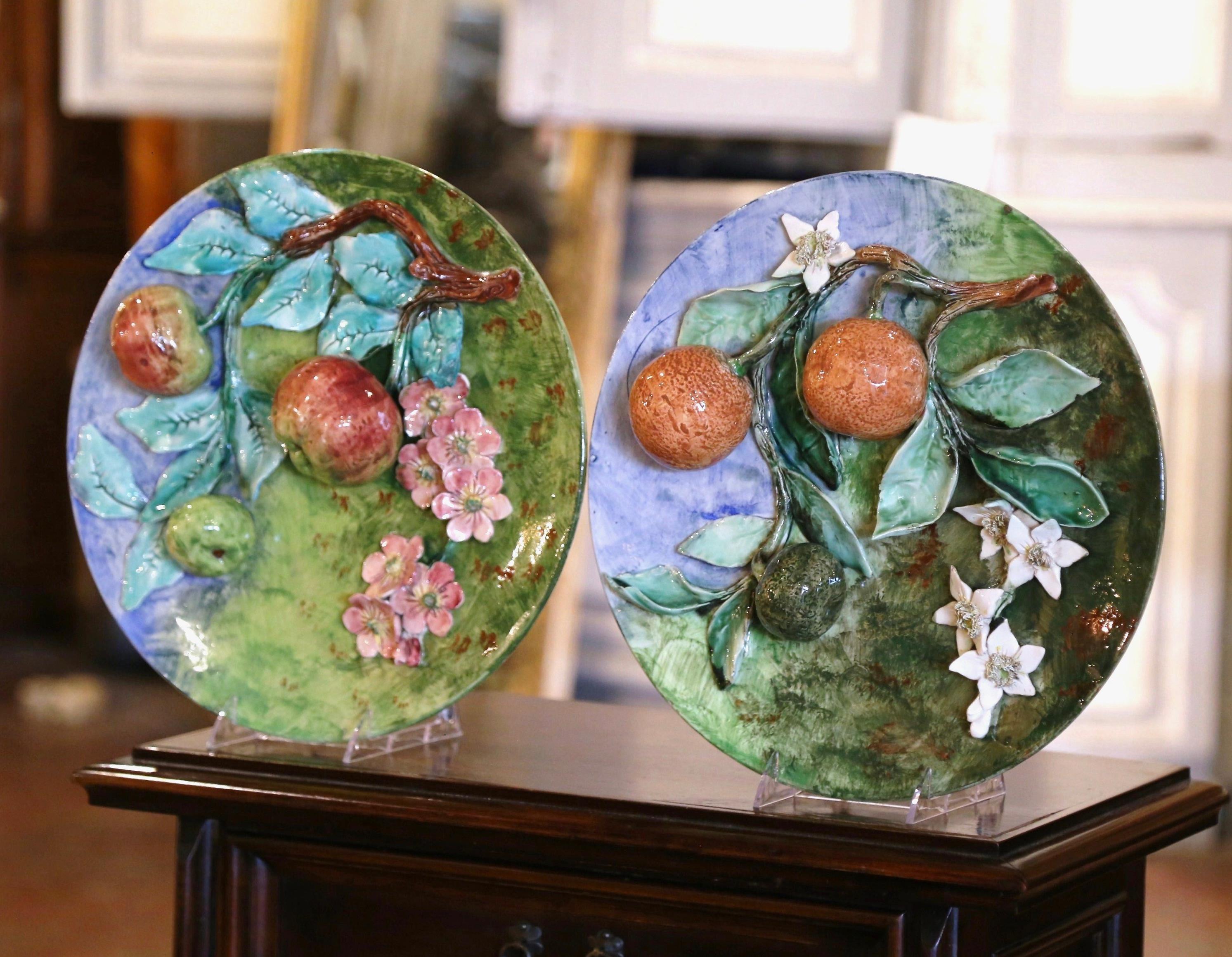 Décorez un mur de cuisine ou une salle de petit déjeuner avec cette paire de grandes assiettes anciennes en majolique. Sculptées en France vers 1880 par Longchamp, deux des assiettes présentent des motifs de fruits sculptés en haut relief, dont