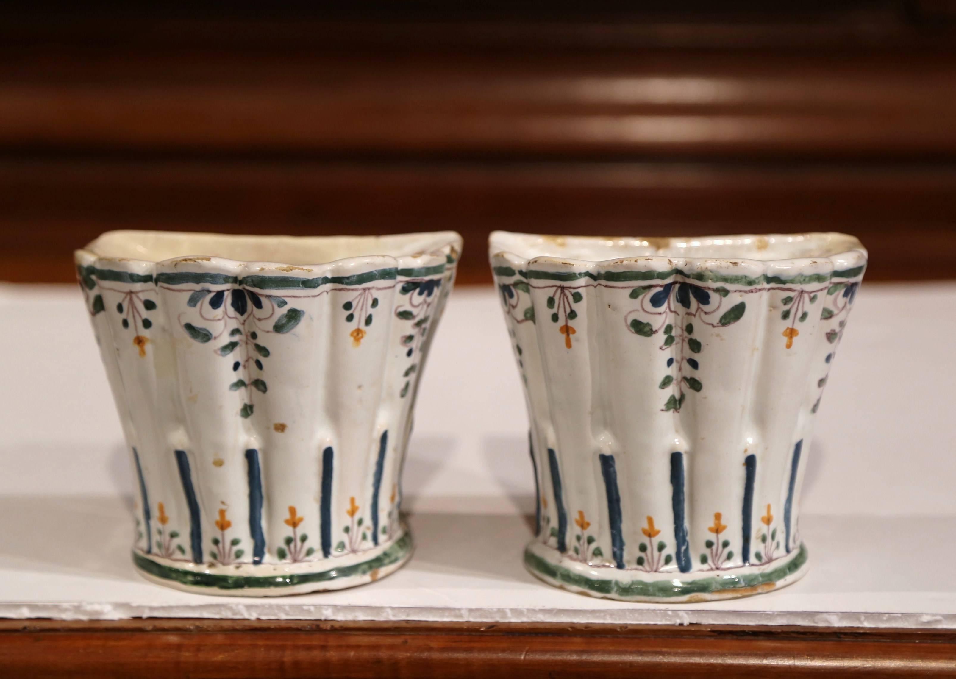 This elegant pair of antique faience bouquetieres (or pique-fleurs) were sculpted in France, circa 1850. These hand-painted vases feature colorful floral motifs in the blue, green and white palette colors. The flower holders have small holes on the