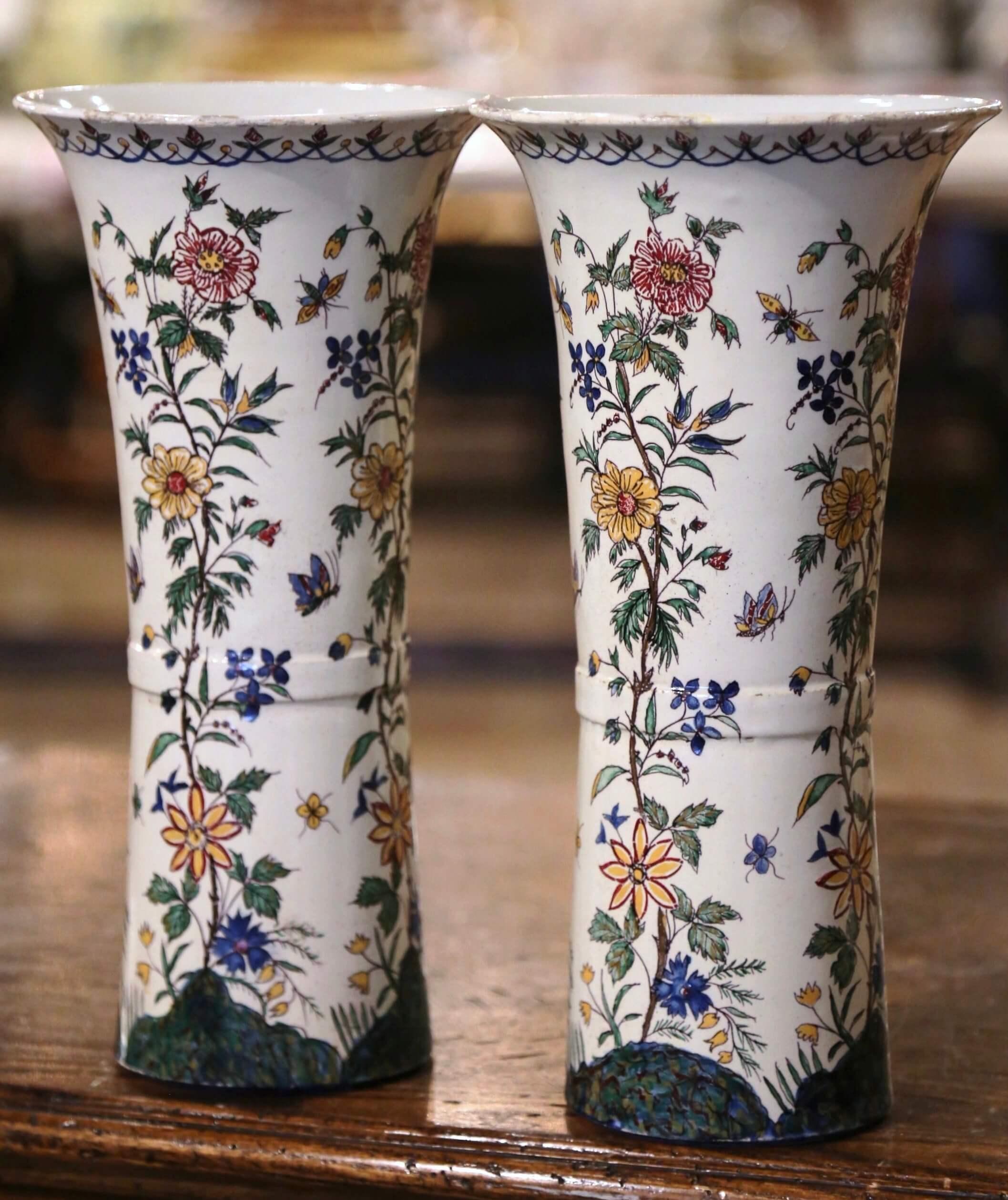 Incorporate beautiful colors into your home with this fine pair of antique ceramic vases from southern France. Crafted circa 1880, the vases are ornate in decoration yet simple in shape. The tall, colorful vases feature a circular bottom and a wide