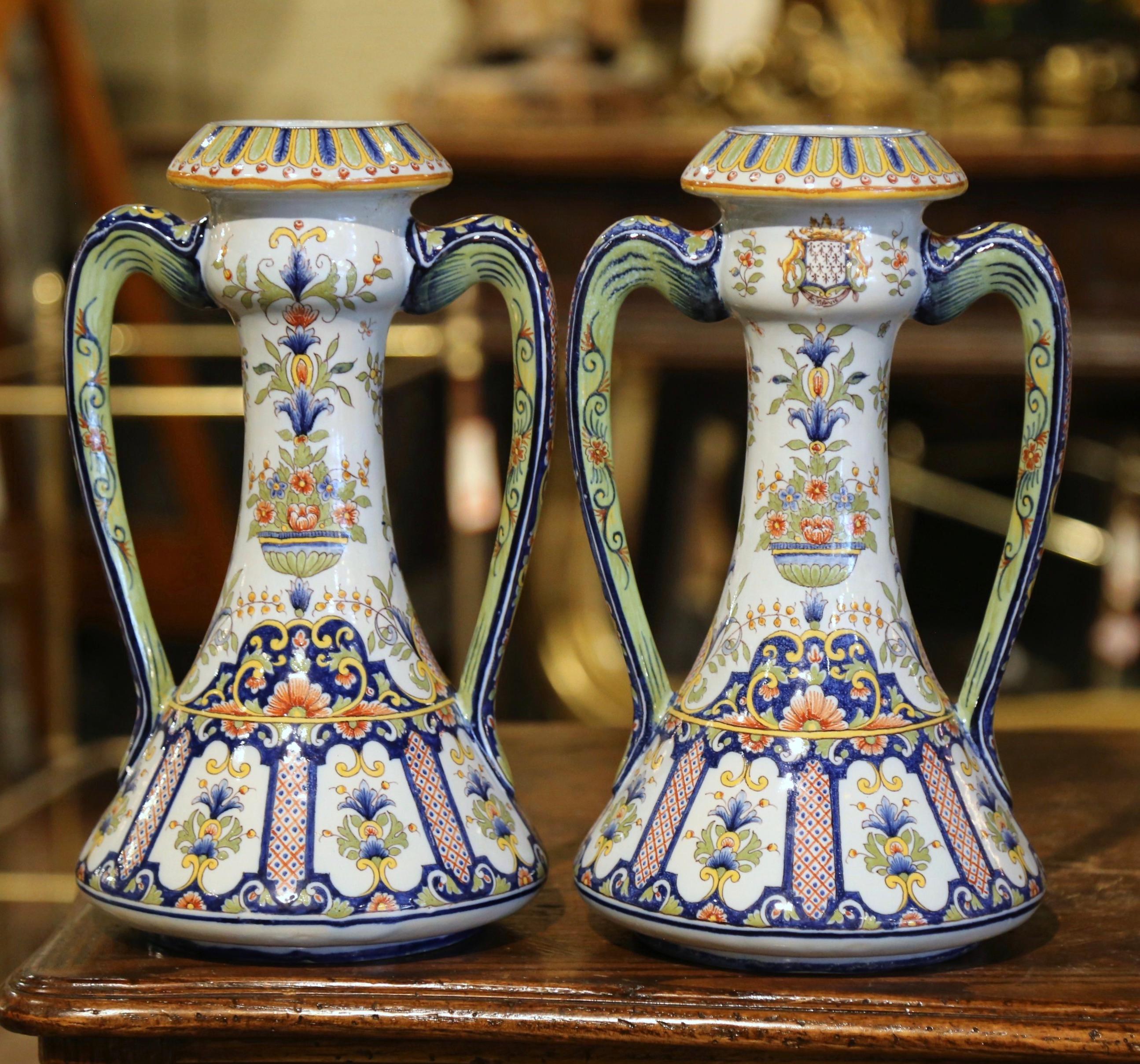 These colorful antique vases were crafted in Normandy, circa 1890. Each ceramic vase, dressed with elegant side handles is round in shape, and decorated with hand painted floral and leaf motifs in a traditional blue, white and yellow Rouen palette;