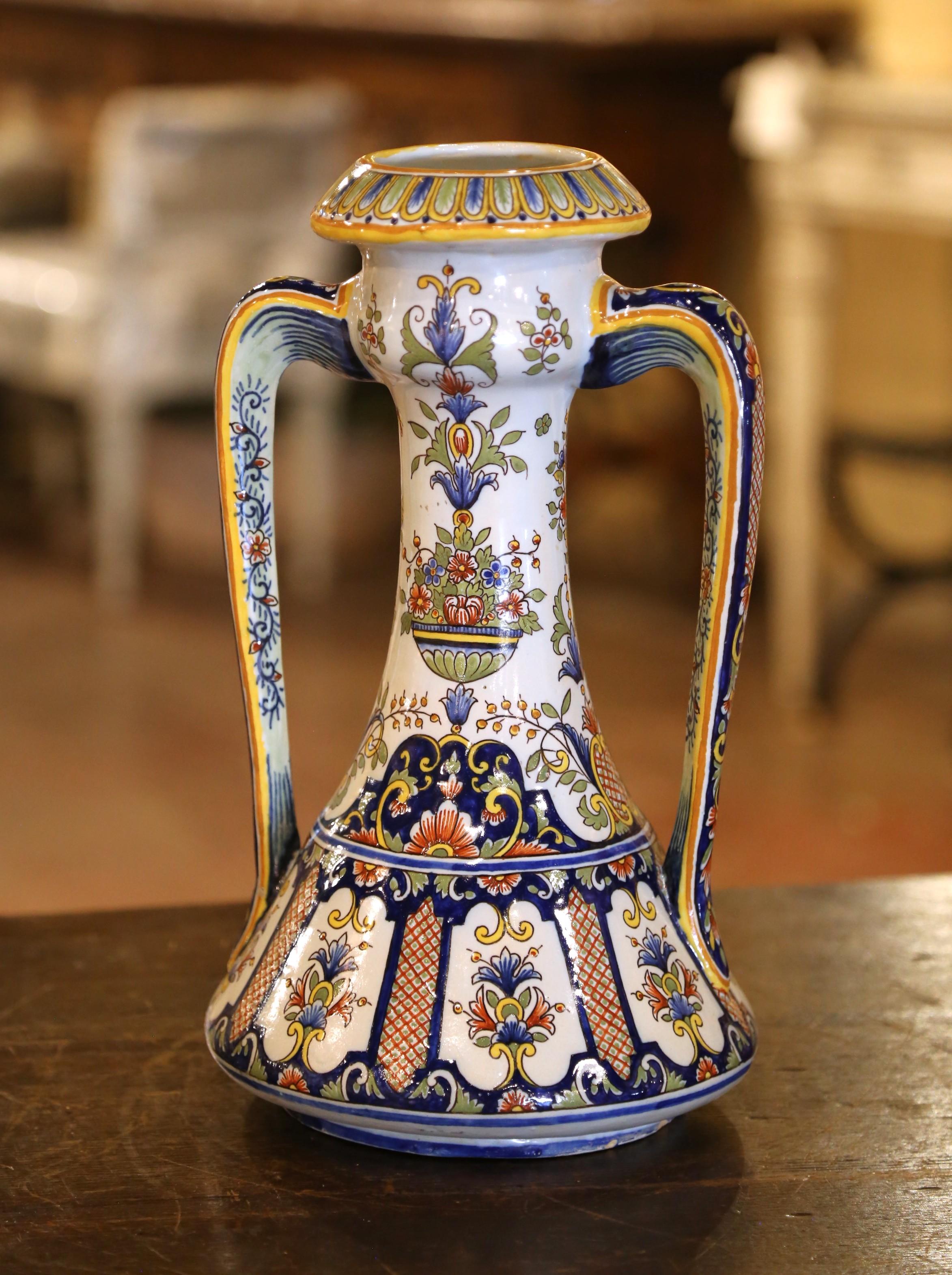 These colorful antique vases were crafted in Normandy, circa 1890. Each ceramic vase, dressed with elegant side handles is round in shape, and decorated with hand painted floral and leaf motifs in a traditional blue, white and yellow Rouen palette;