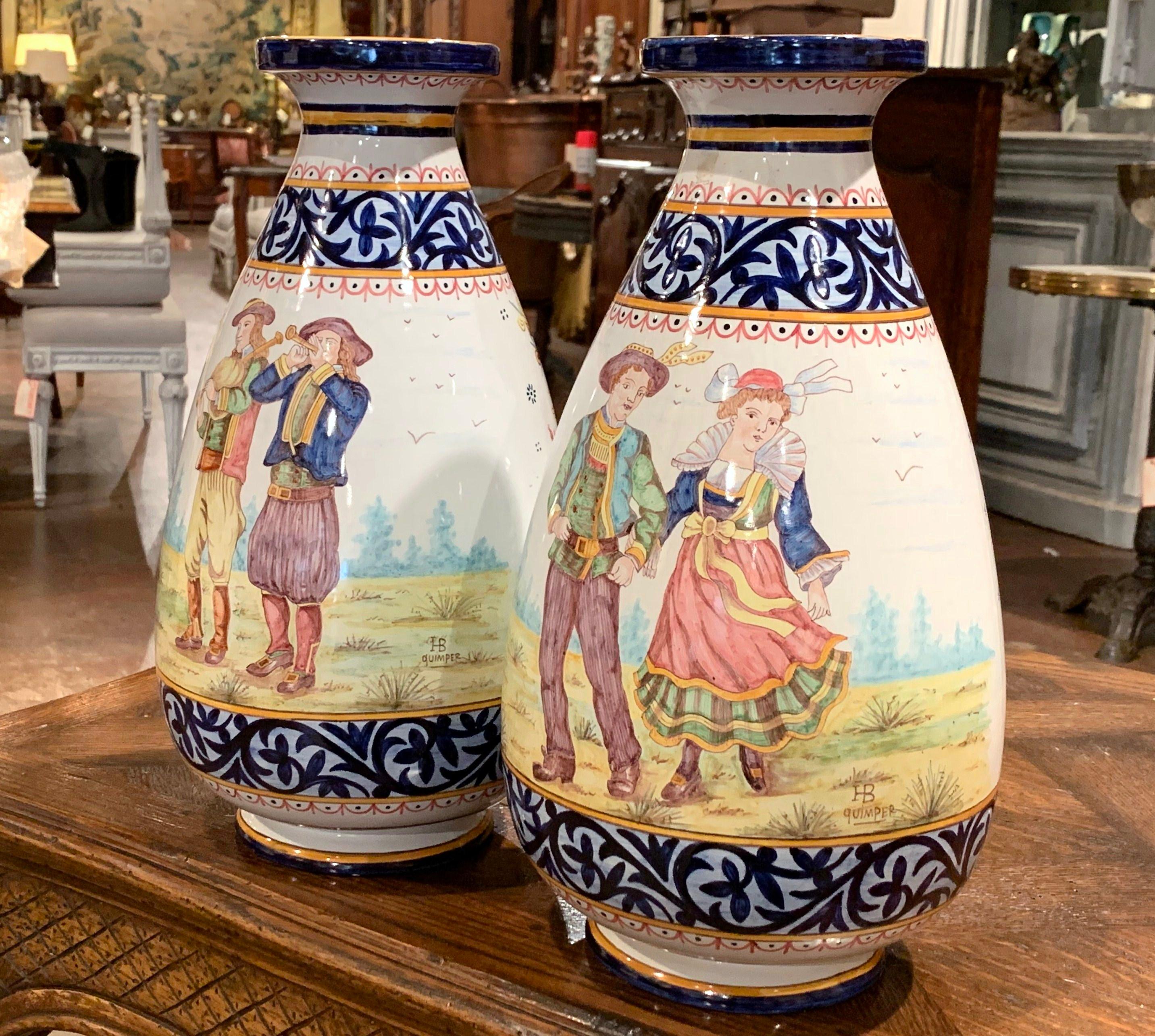 Complete your faience collection with this colorful pair of antique vases from Brittany. Crafted in Quimper, France, circa 1880, both jars are round in shape, and are hand painted with Britons people dressed in traditional outfits and embellished