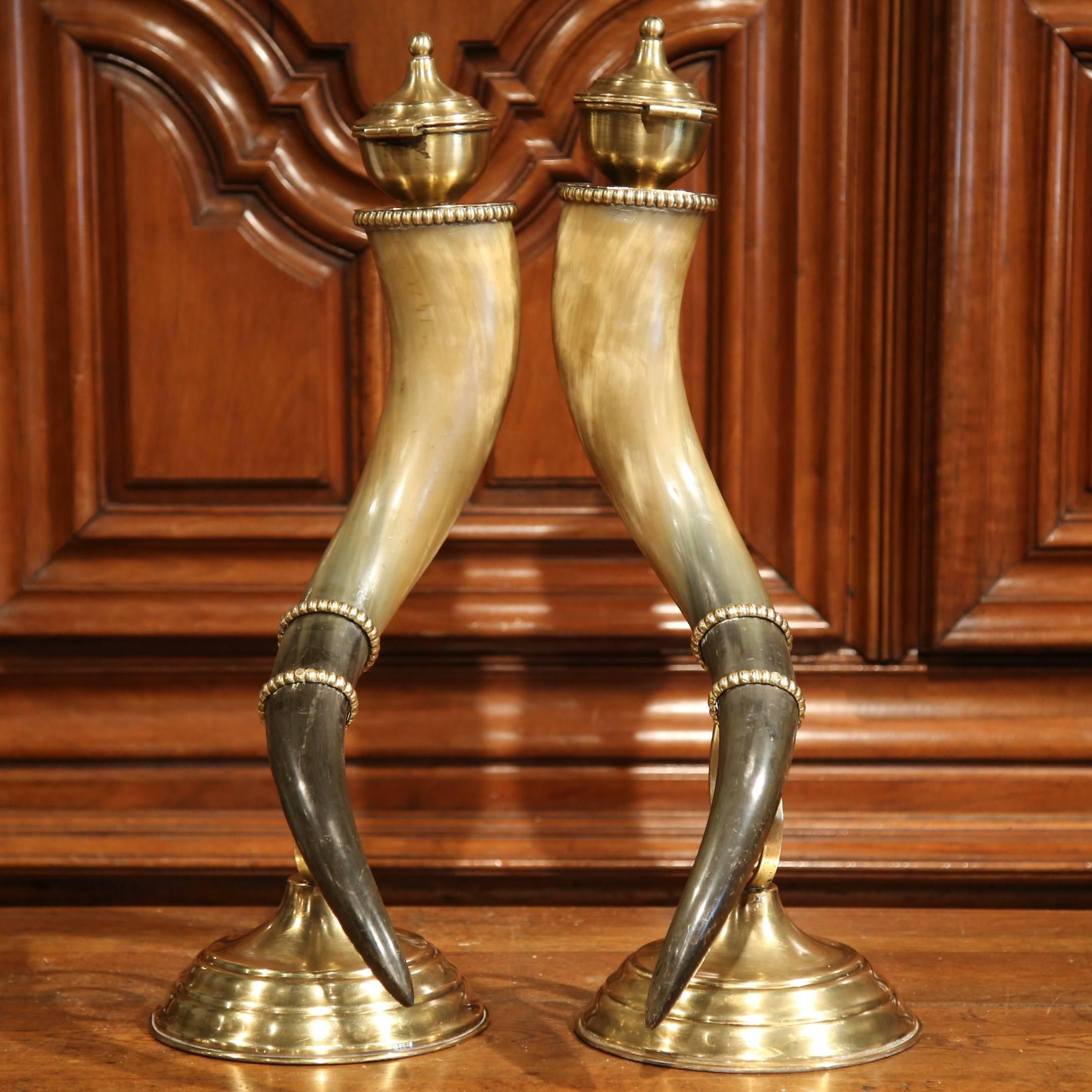 These large, antique drinking horns on stand were crafted in France, circa 1880. Each curved cornucopia dressed with brass ending and lid, is mounted on a round brass stands. The brass additions are decorative, and the lids resemble classical urns.
