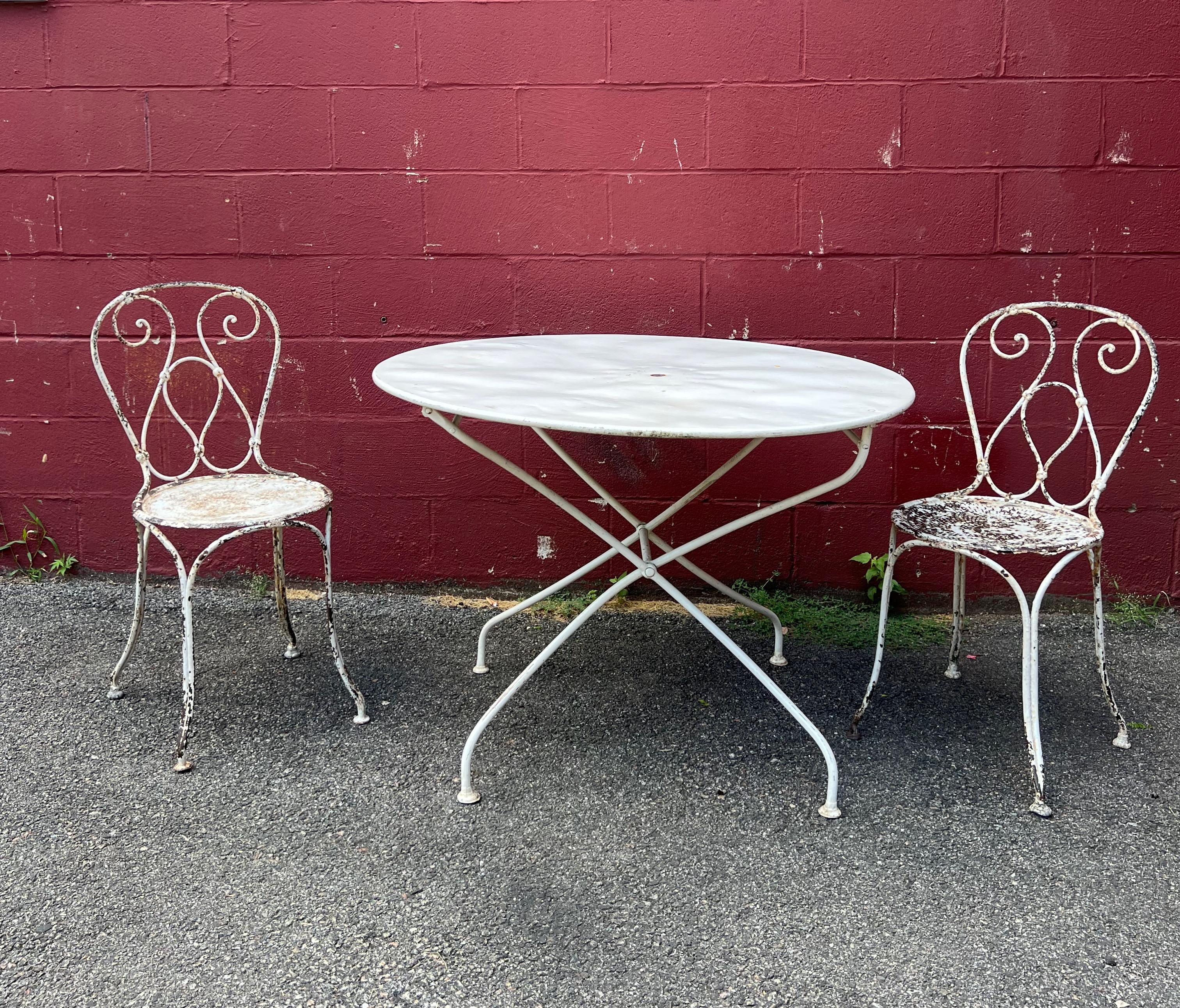 These late 19th Century French iron garden chairs are the perfect addition to any outdoor space. The classic scrolled design is especially nice on this unusual pair, with one seat made of perforated metal and the other solid with no perforations.