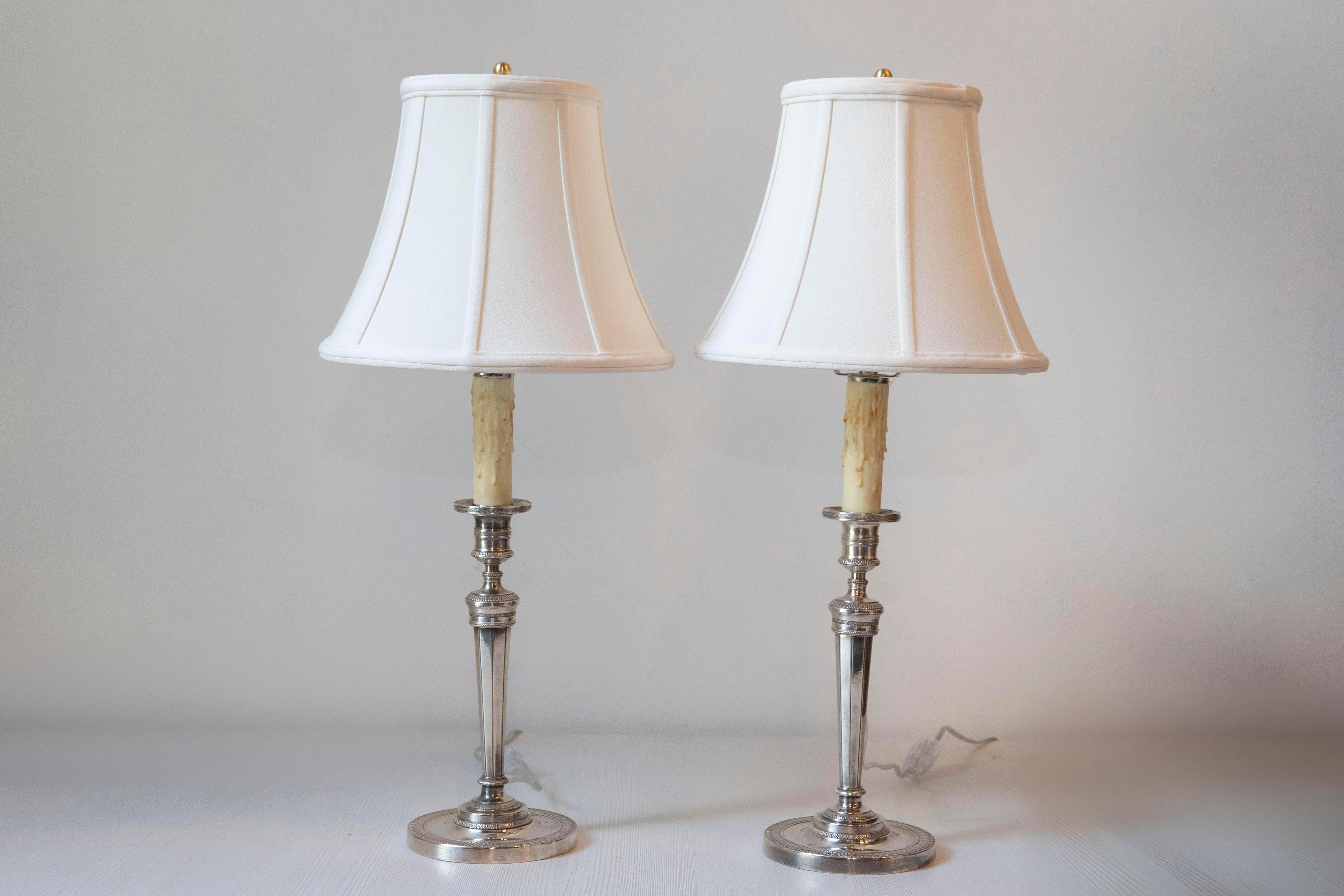 Questa elegante coppia di lampade francesi del XIX secolo sfoggia un design senza tempo e una lavorazione impeccabile. Realizzate in metallo argentato, le lampade presentano una classica silhouette a balaustro con colonne scanalate e affusolate che