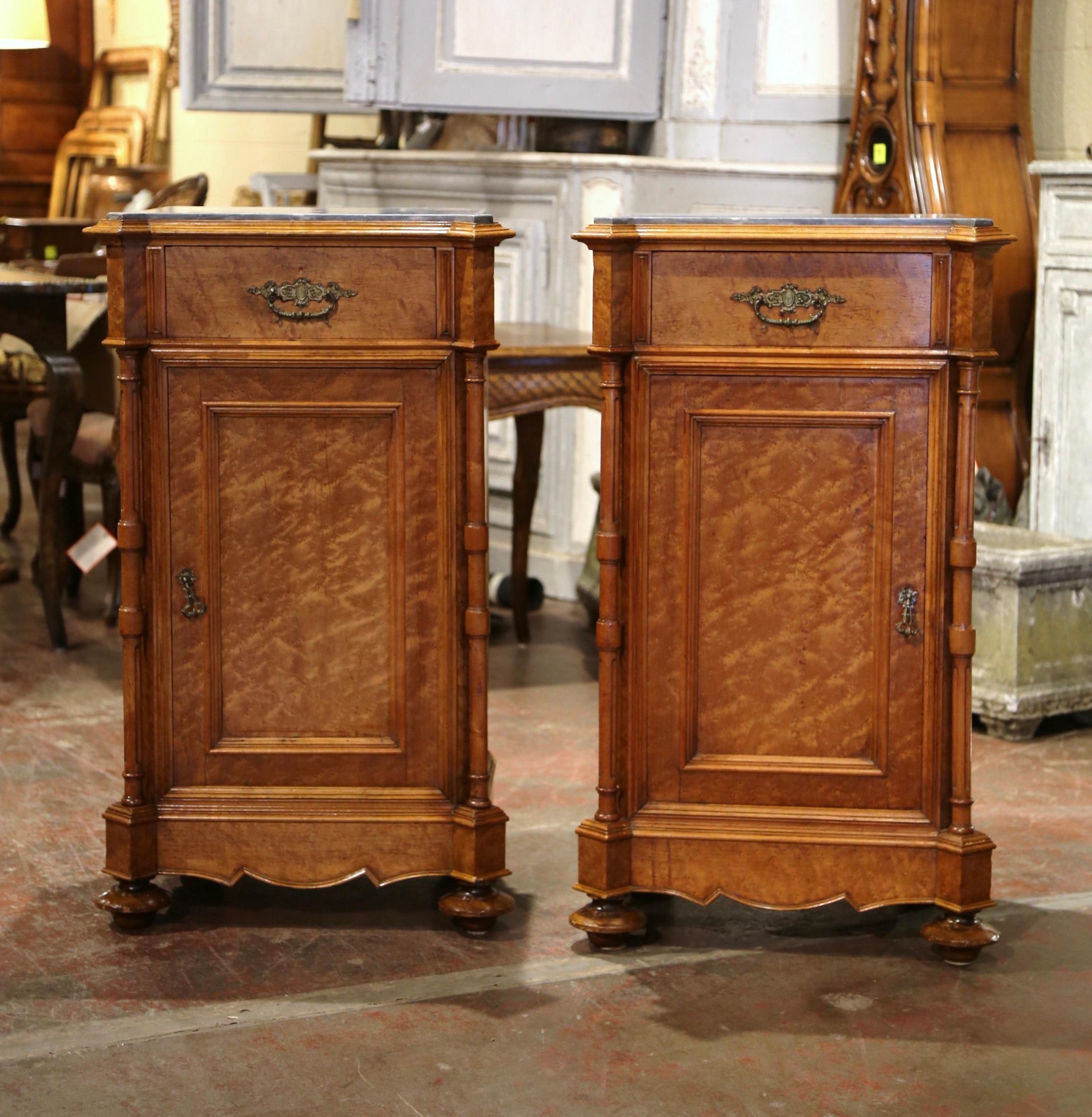 Decorate a master bedroom or guest room with this true pair of antique nightstands, one opening to the right, the other to the left! Crafted in France, circa 1870, each cabinet built of Birdseye maple, stands on turned bun feet over a plinth base;