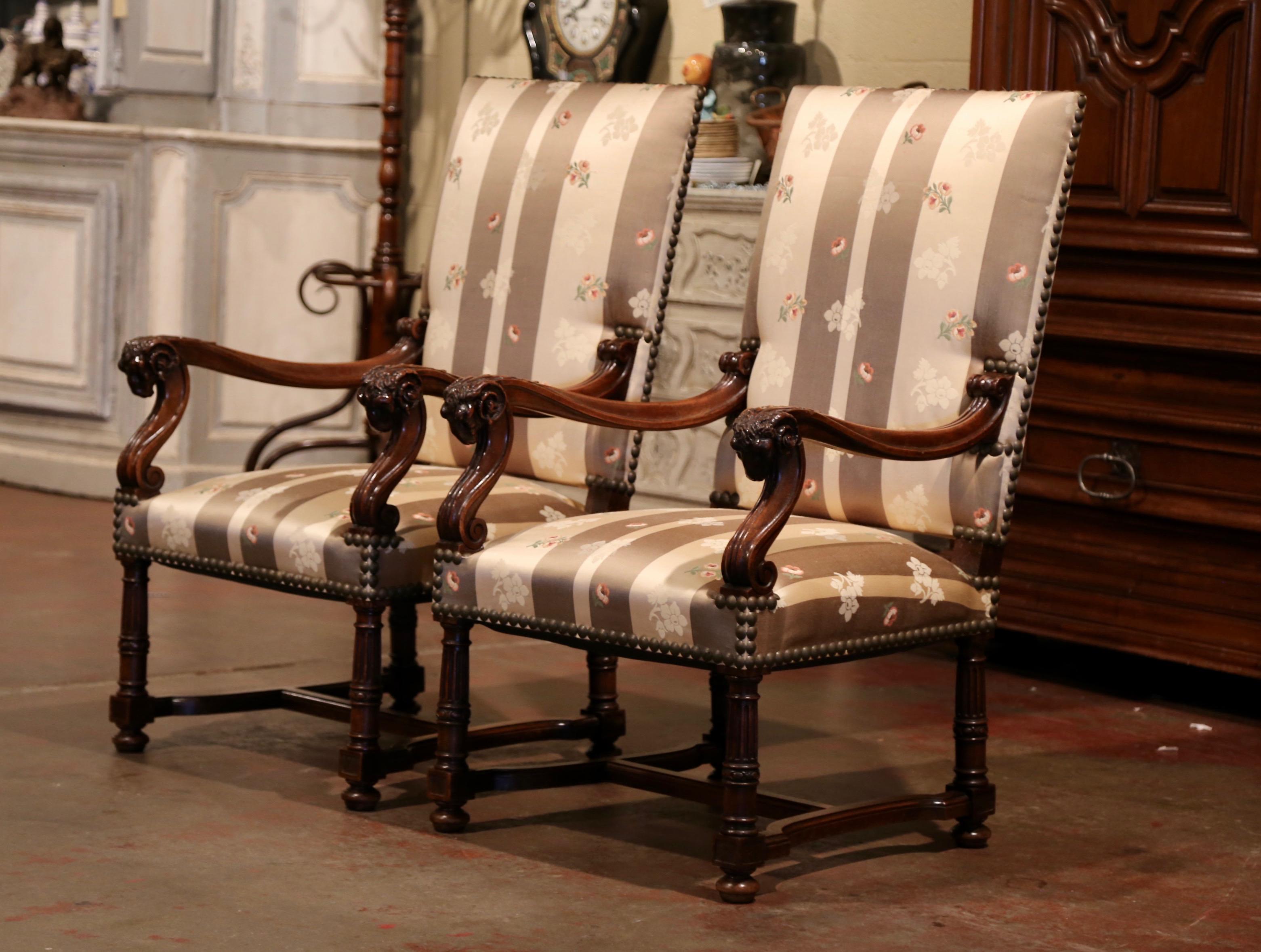 Decorate a den, a study or an office with this elegant pair of antique walnut armchairs. Crafted in Southern France, circa 1870, each tall fruitwood chair stands on straight turned legs over a bottom stretcher, the armchair features a tall