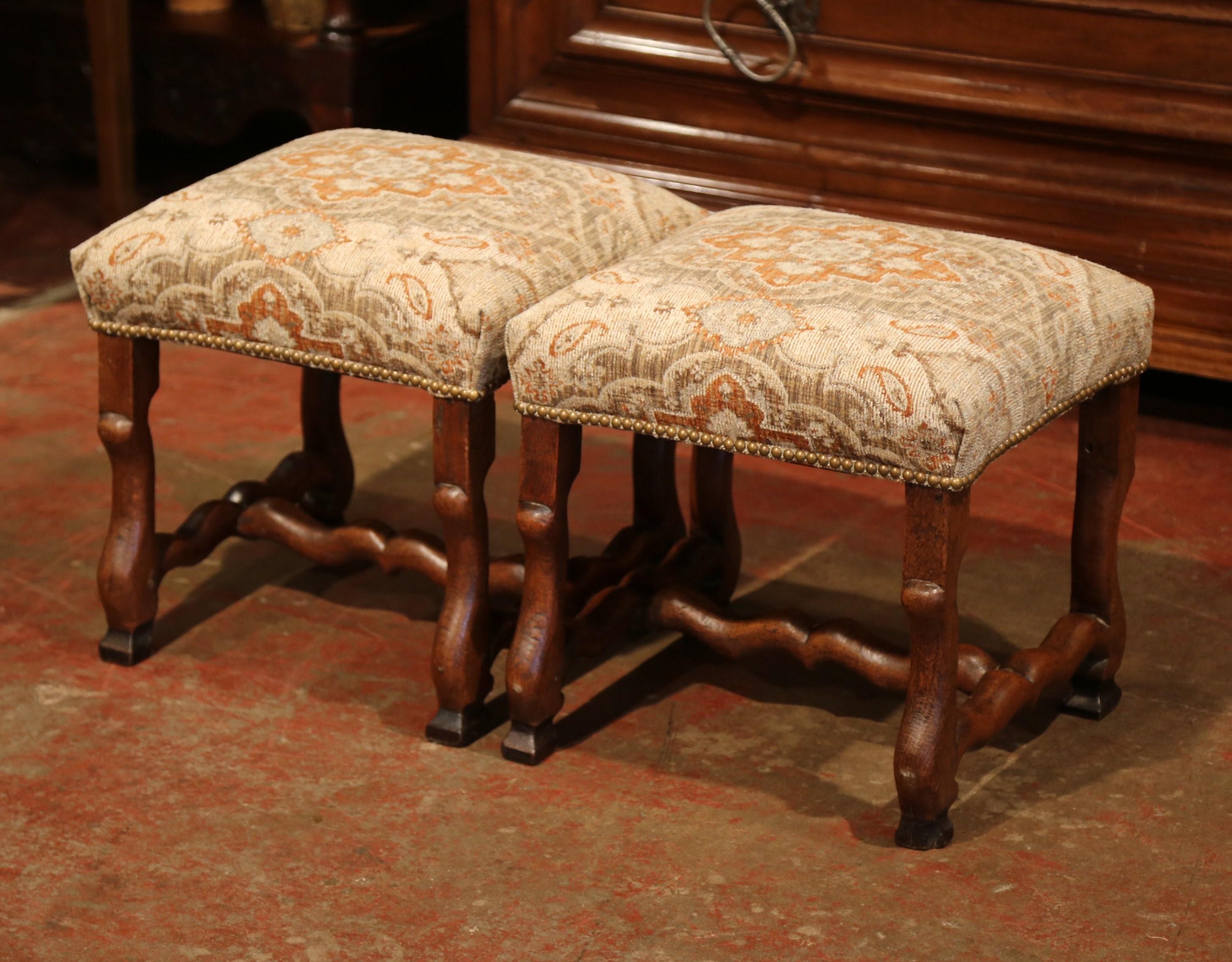 These elegant antique stools were crafted in Southern France, circa 1880. The fruitwood pieces feature fine, hand-carved scrolled sheep bone legs with a decorative curved stretcher. The 