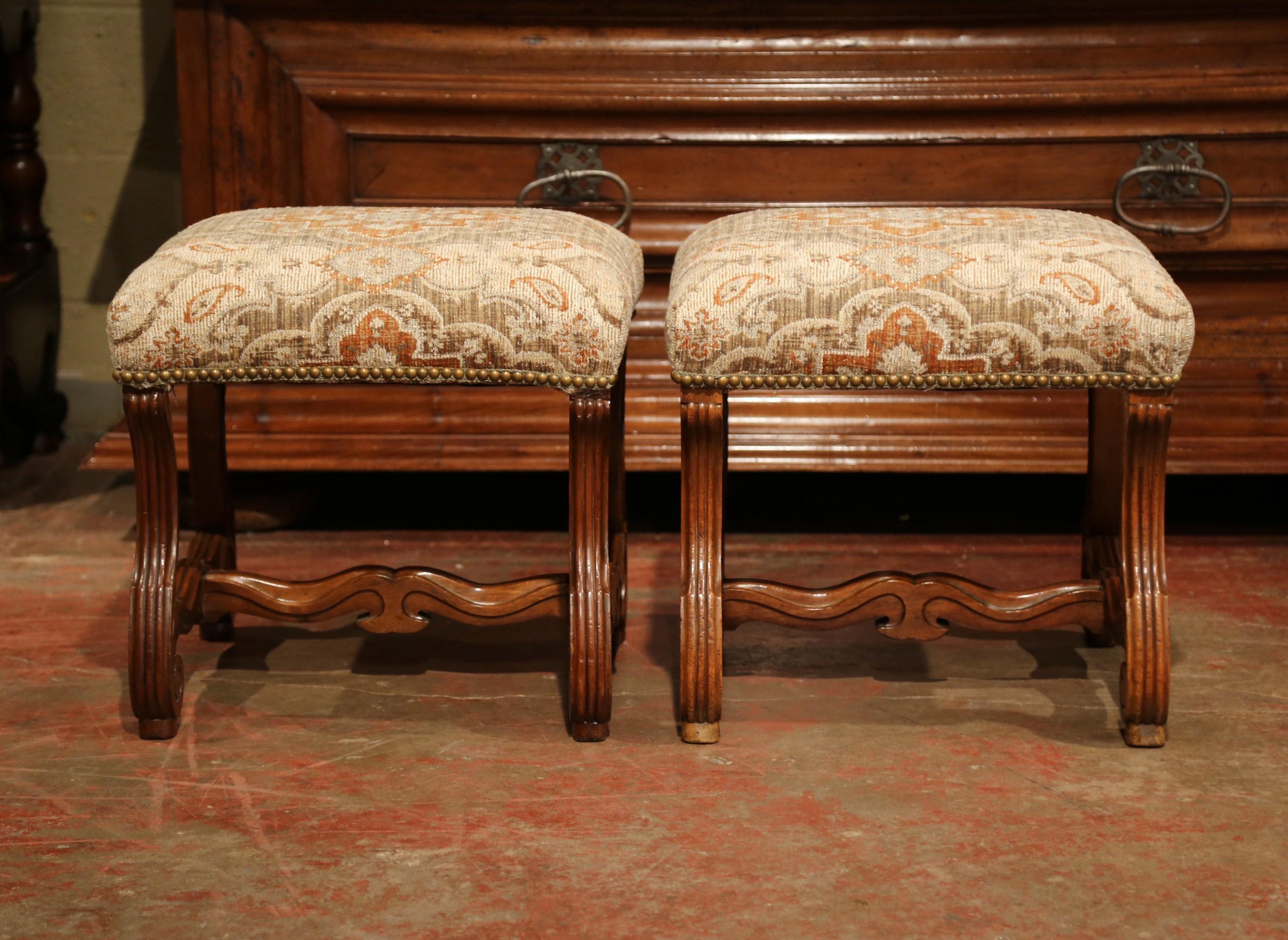 These elegant antique stools, were crafted in the Perigord region of France, circa 1860. The fruit wood seating pieces feature fine, hand-carved sheep bone scrolled legs with a decorative stretcher. The 