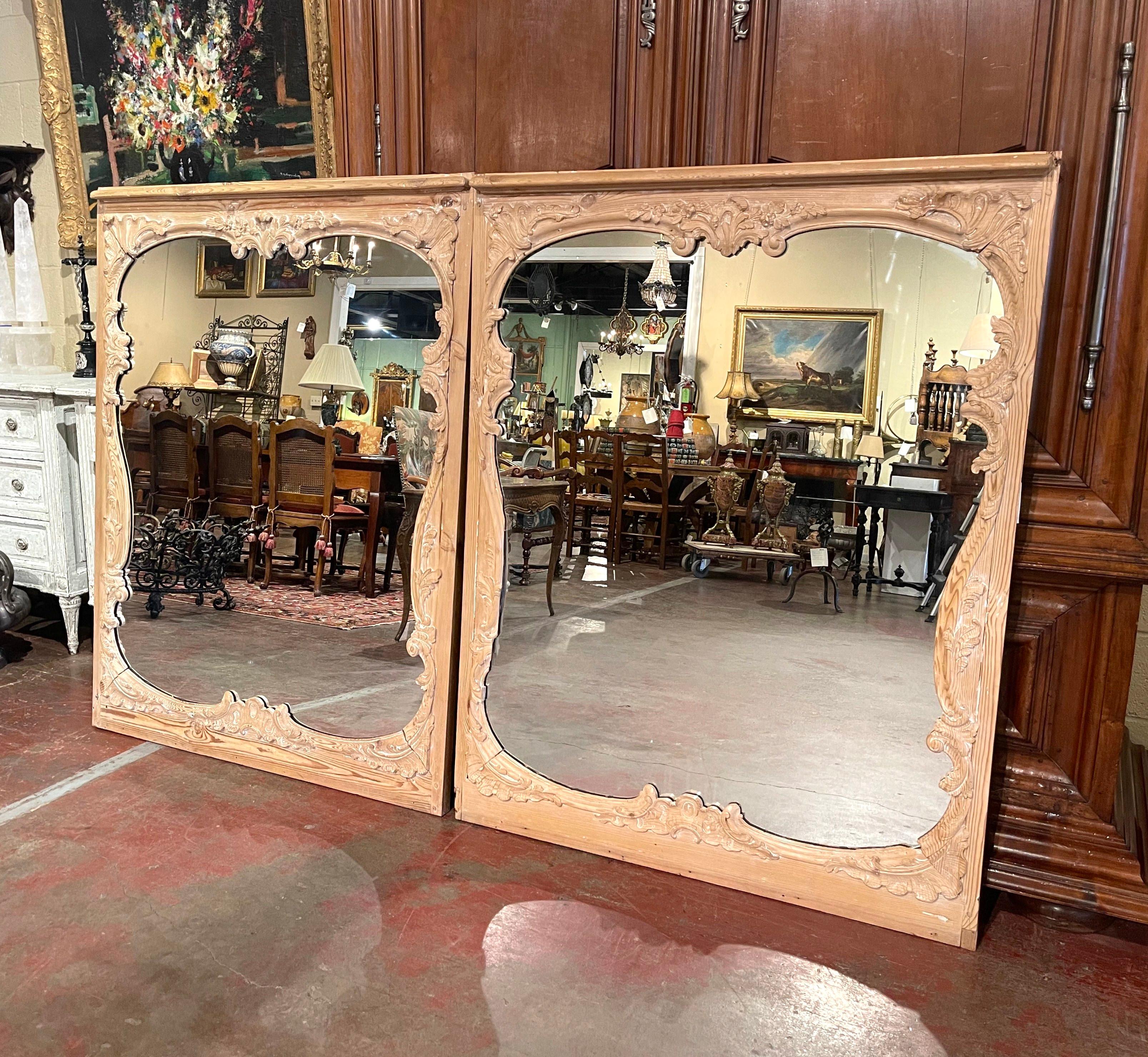 Place these elegant antique mirrors over a pair of consoles or chests in entryway! Crafted in France circa 1880 and made of pine wood, each rectangular wall mirror features hand carved floral and leaf motifs throughout. Both Rococo mirrors are in