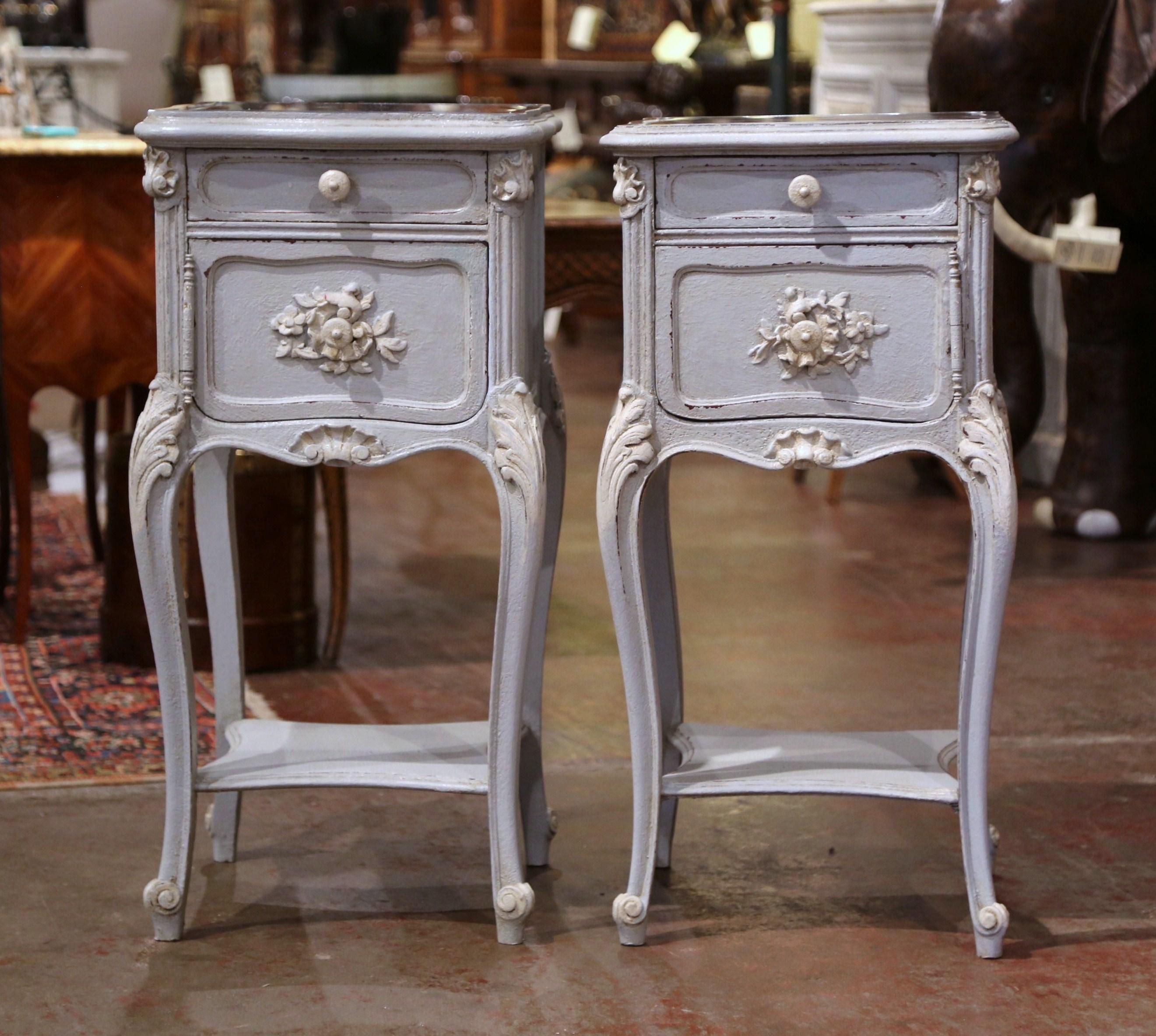 Complete your bedroom with this elegant pair of antique bedside tables from France, crafted, circa 1880. The tables are almost square in shape and are hand painted in a grey-blue and white palette. Each small cabinet stands on cabriole legs with