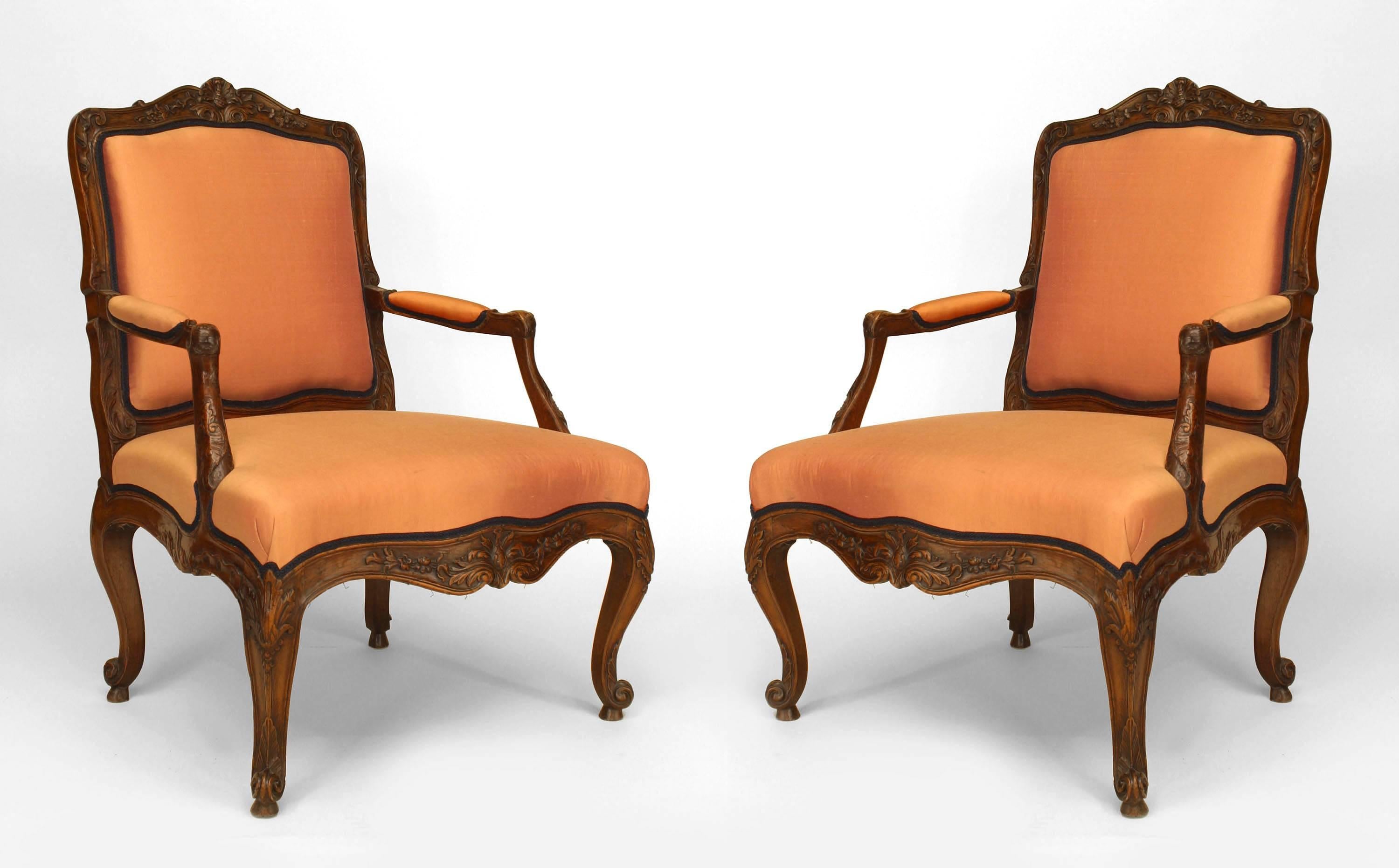 Ein Paar offener Sessel im französischen Louis XV-Stil (19. Jh.) aus geschnitztem Nussbaumholz mit geformter Rückenlehne und rosa gepolstertem Sitz und Rückenlehne
