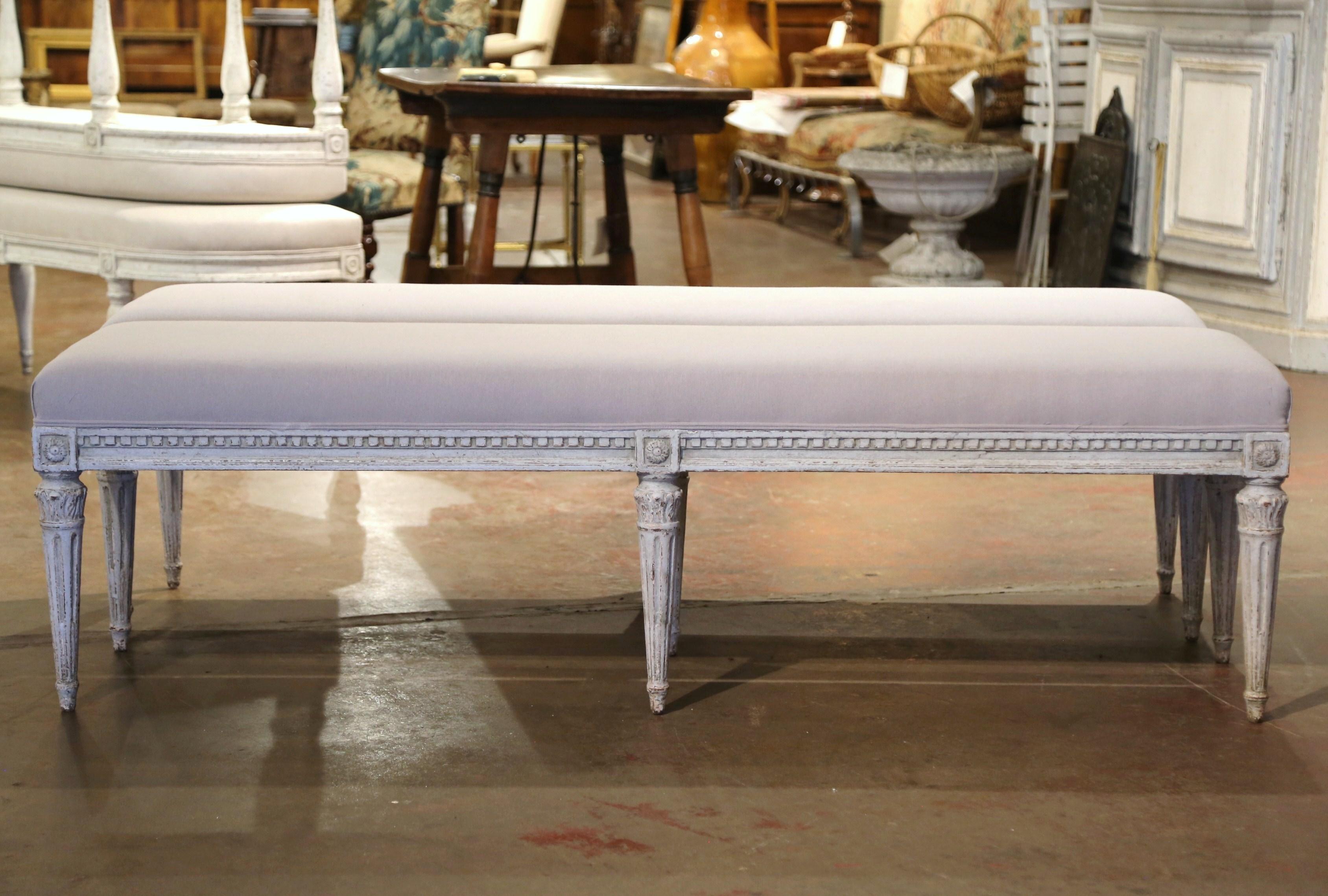Complete your entryway or living room with this pair of antique painted benches. Crafted in France, circa 1880 and rectangular in shape, each long bench stands on six tapered and fluted legs decorated with floral rosettes medallions and acanthus