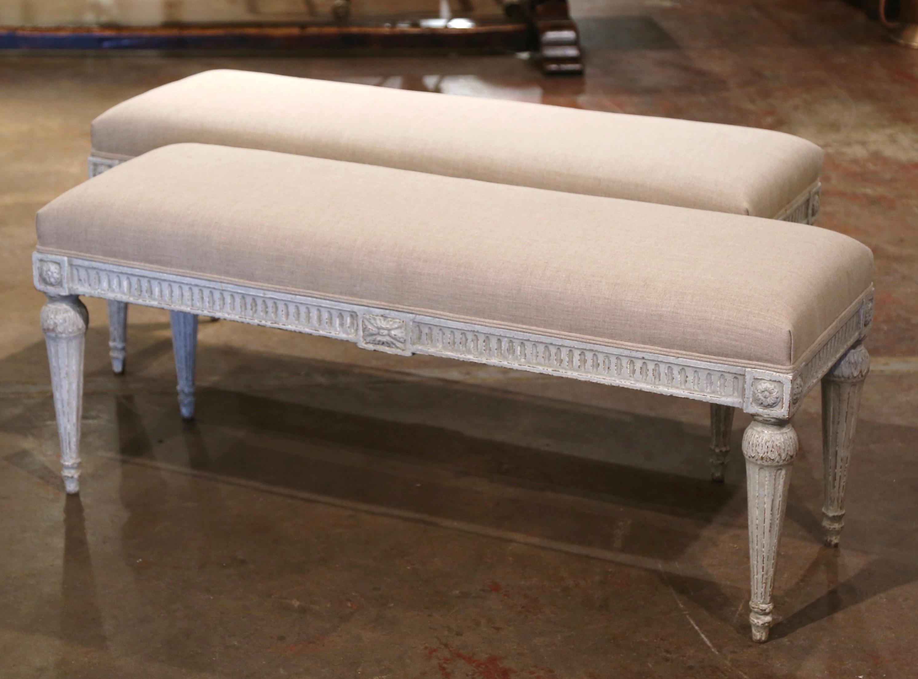 Complete your entryway or hallway with this elegant pair of antique benches. Created in France, circa 1890, and rectangular in shape, the benches sit on four tapered and fluted legs decorated with carved floral medallions at each corner, and feature