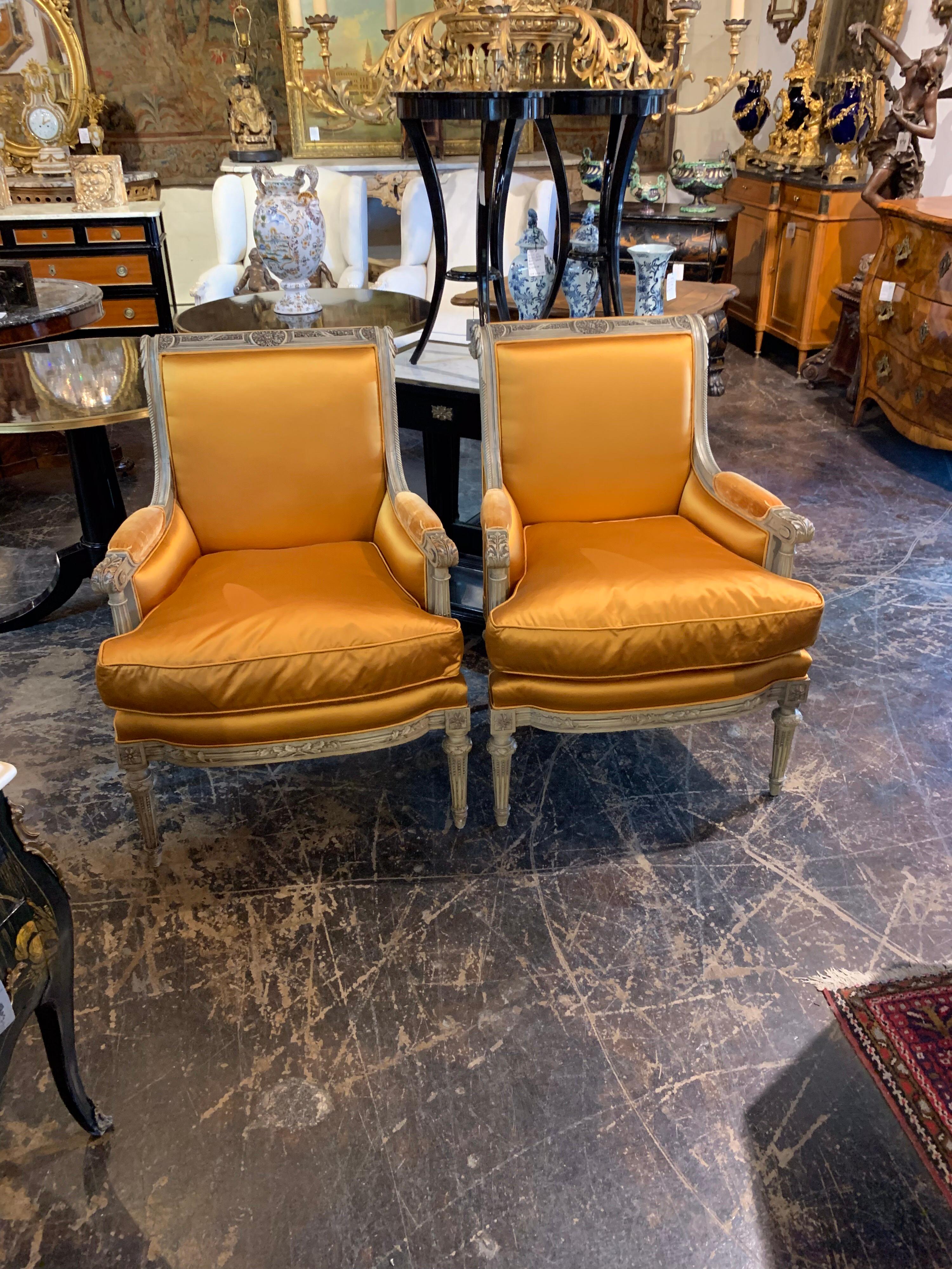 Very lush pair of 19th century French Louis XVI style carved and lacquered armchairs.
The carvings are gorgeous and the chairs are upholstered in an orange or gold silk. These elegant chairs would look great in your living room and they are quite