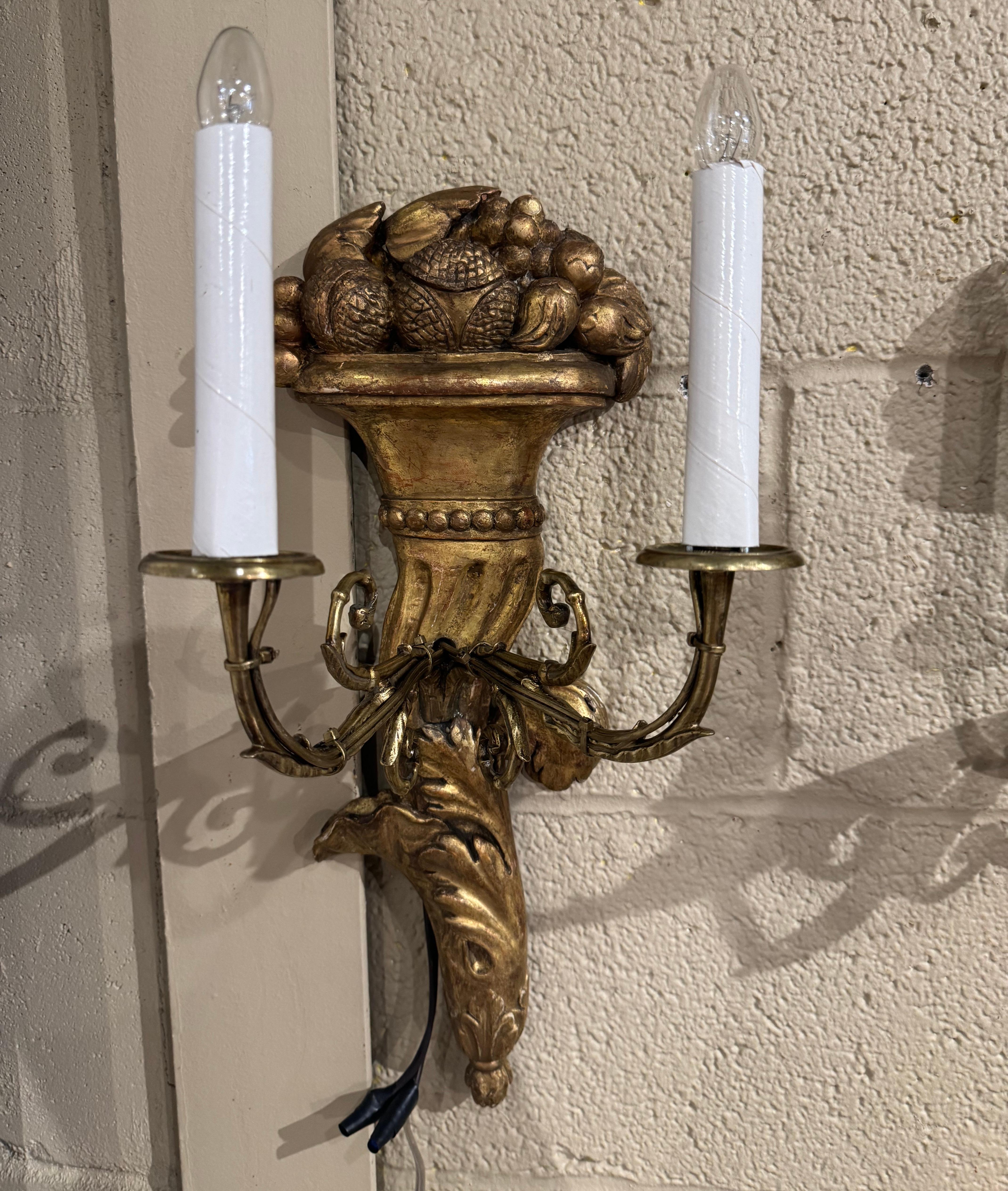 Patinated Pair of 19th Century French Louis XVI Carved Giltwood Two-Light Wall Sconces For Sale