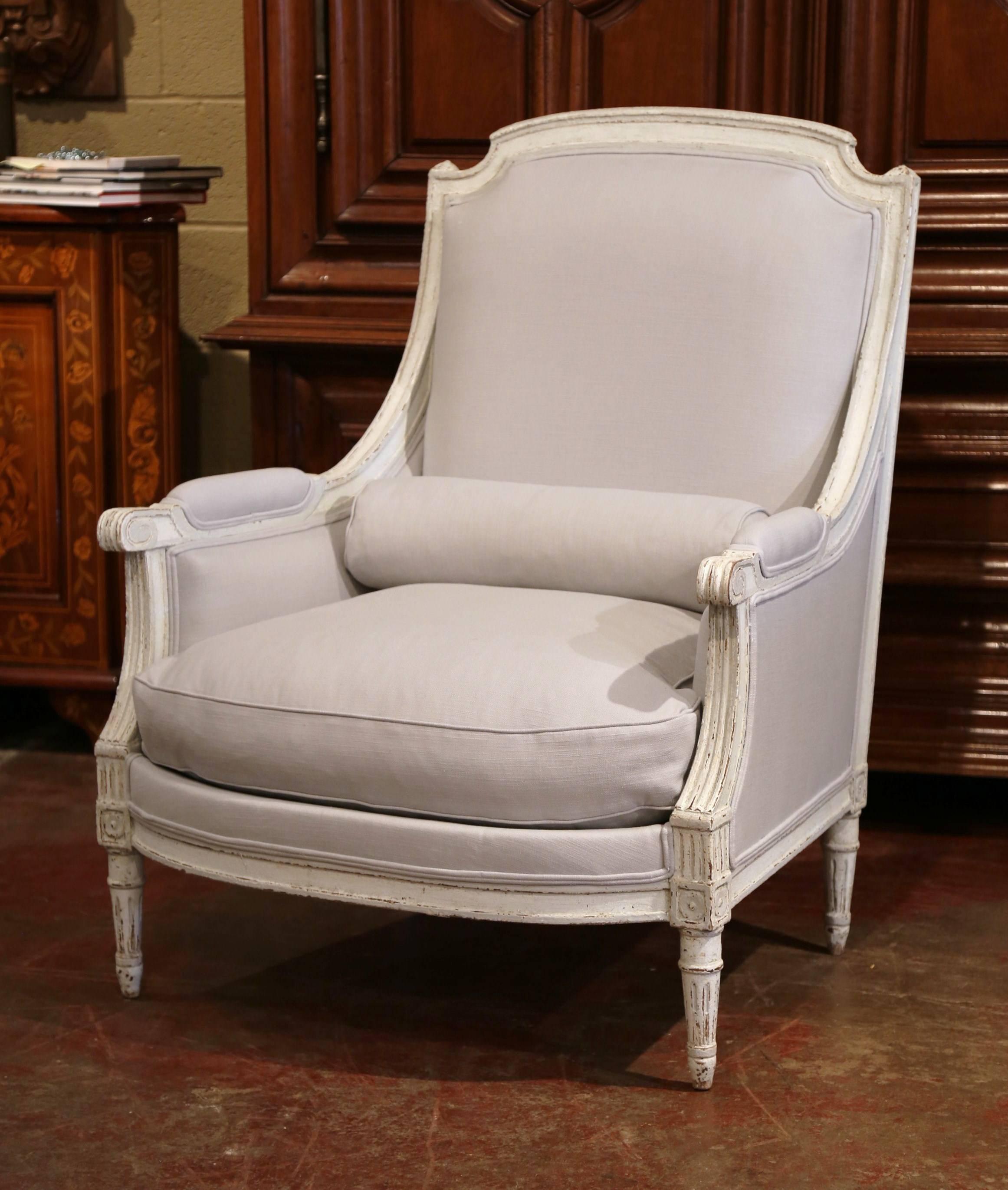 This elegant pair of antique armchairs was created in France, circa 1880. The large armchairs with tall arched back, feature a hand-carved frame, tapered legs with square medallions, armrests on both sides and comfortable, plush down seat cushions.